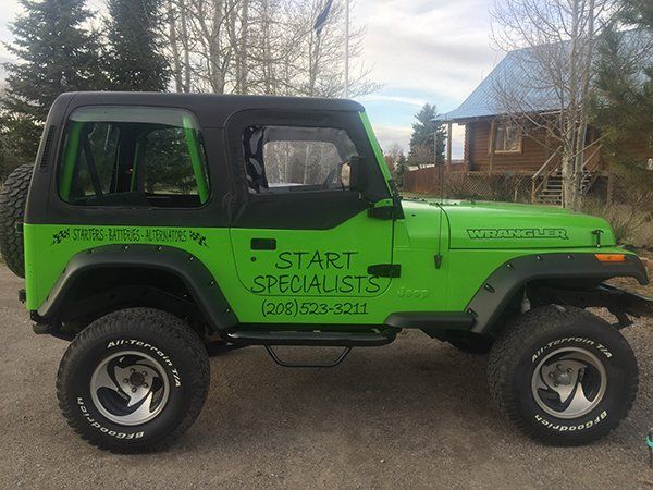 A green jeep is parked in front of a house that says start specialists
