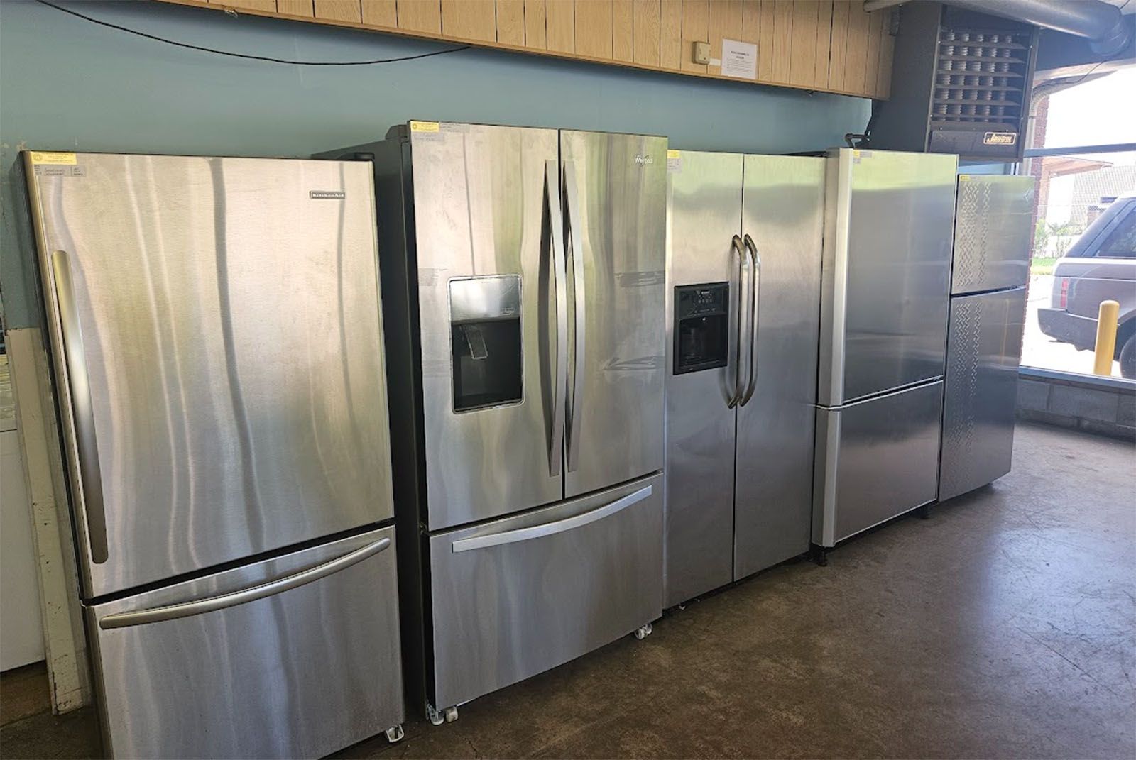 Row of stainless steel refrigerators in a store display area