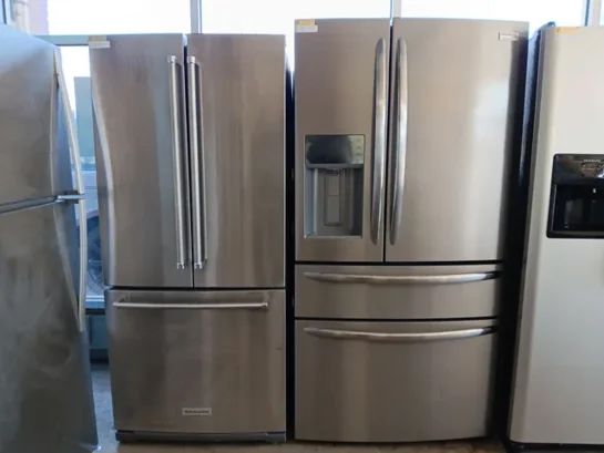 A row of stainless steel refrigerators are lined up in a room.