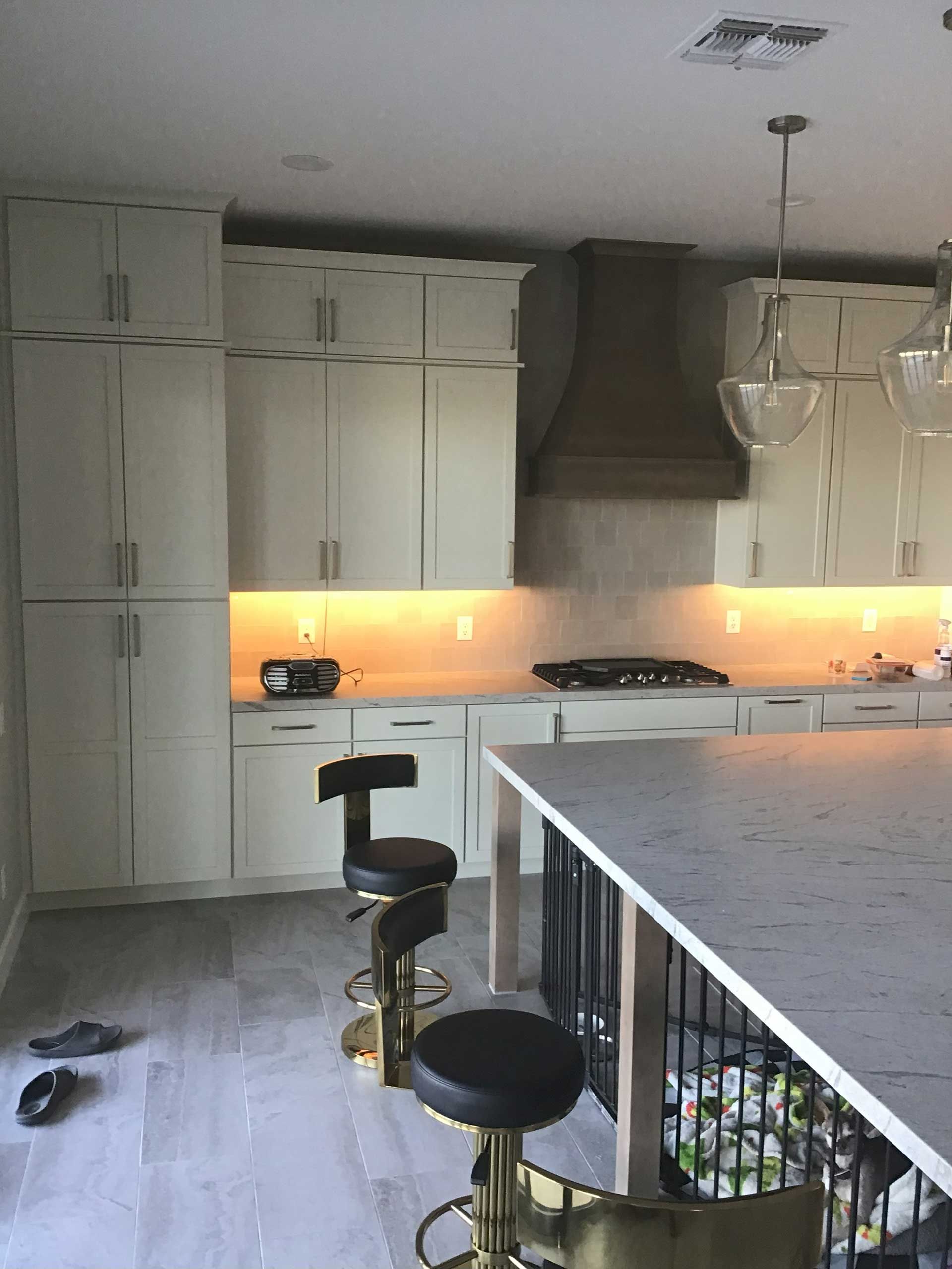kitchen with white cabinets, island, and stools