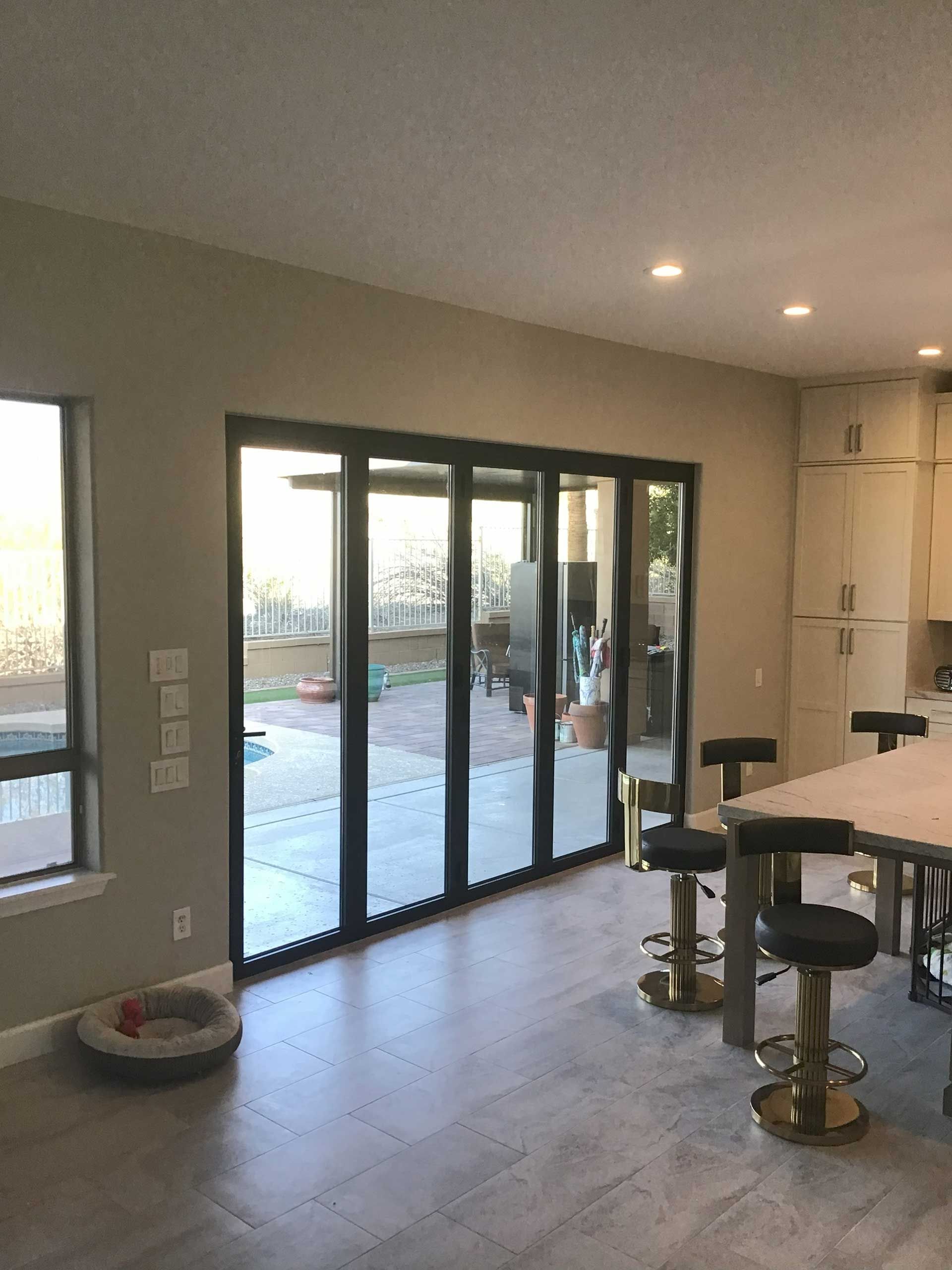 interior view of a modern kitchen with a large folding glass door leading to an outdoor patio