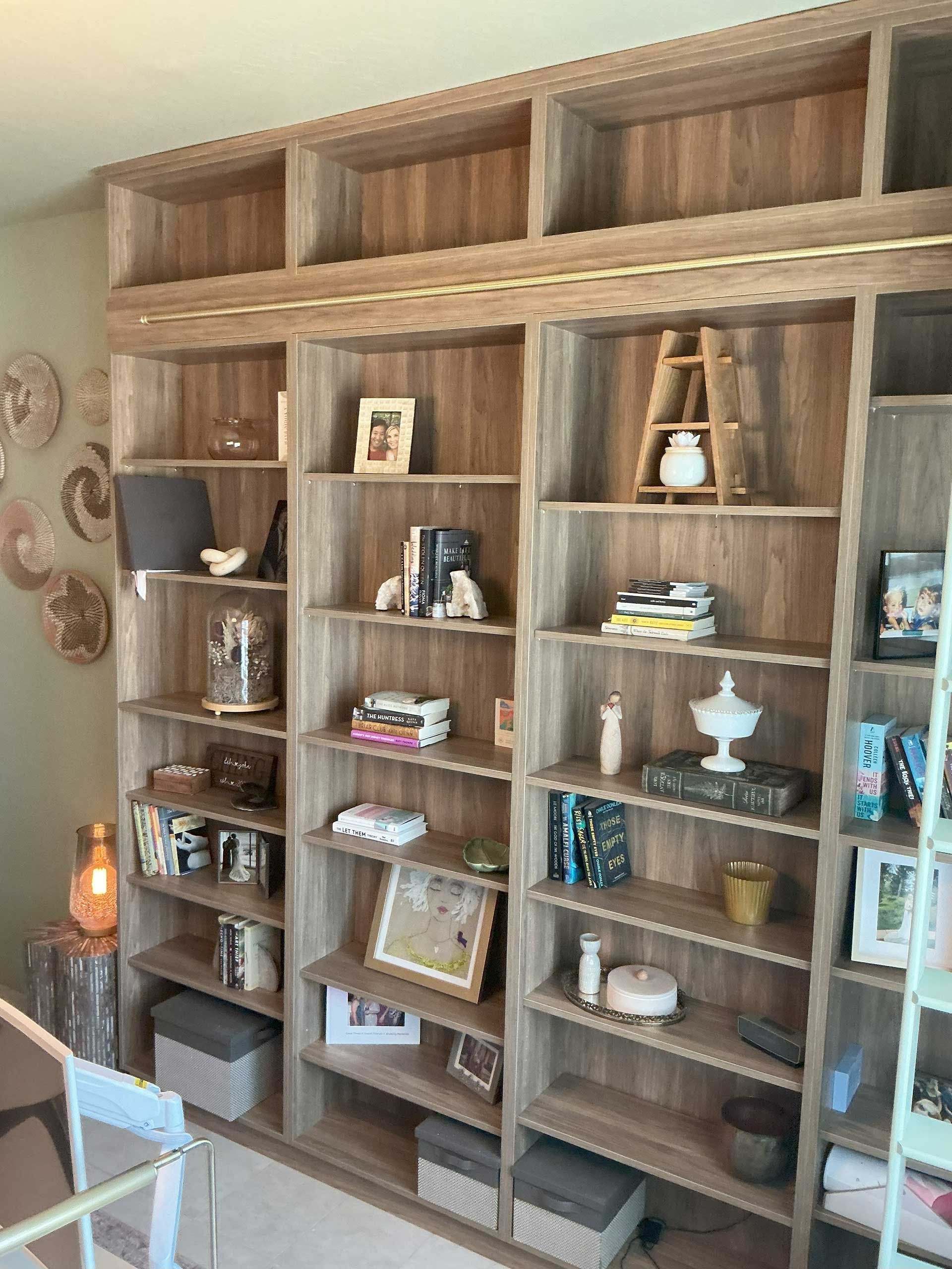 wooden built-in bookshelves filled with books, decor, and storage boxes
