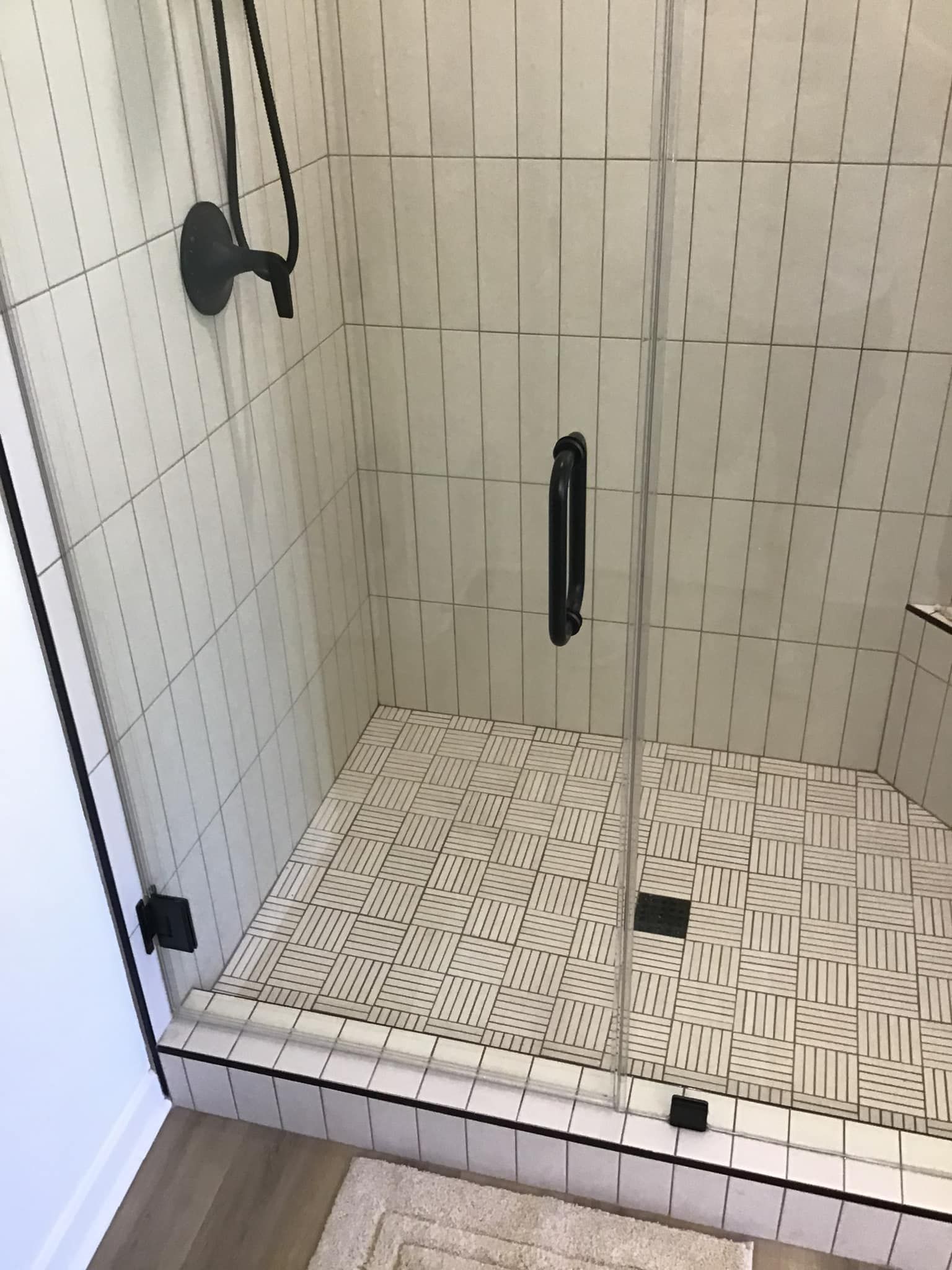 A bathroom with a walk in shower with a glass door.