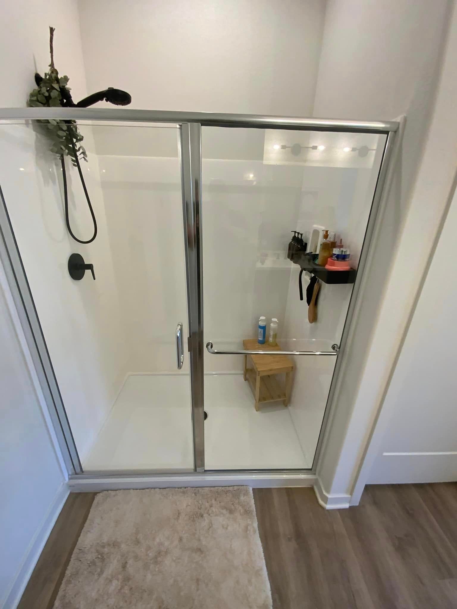 A bathroom with a walk in shower with a sliding glass door.