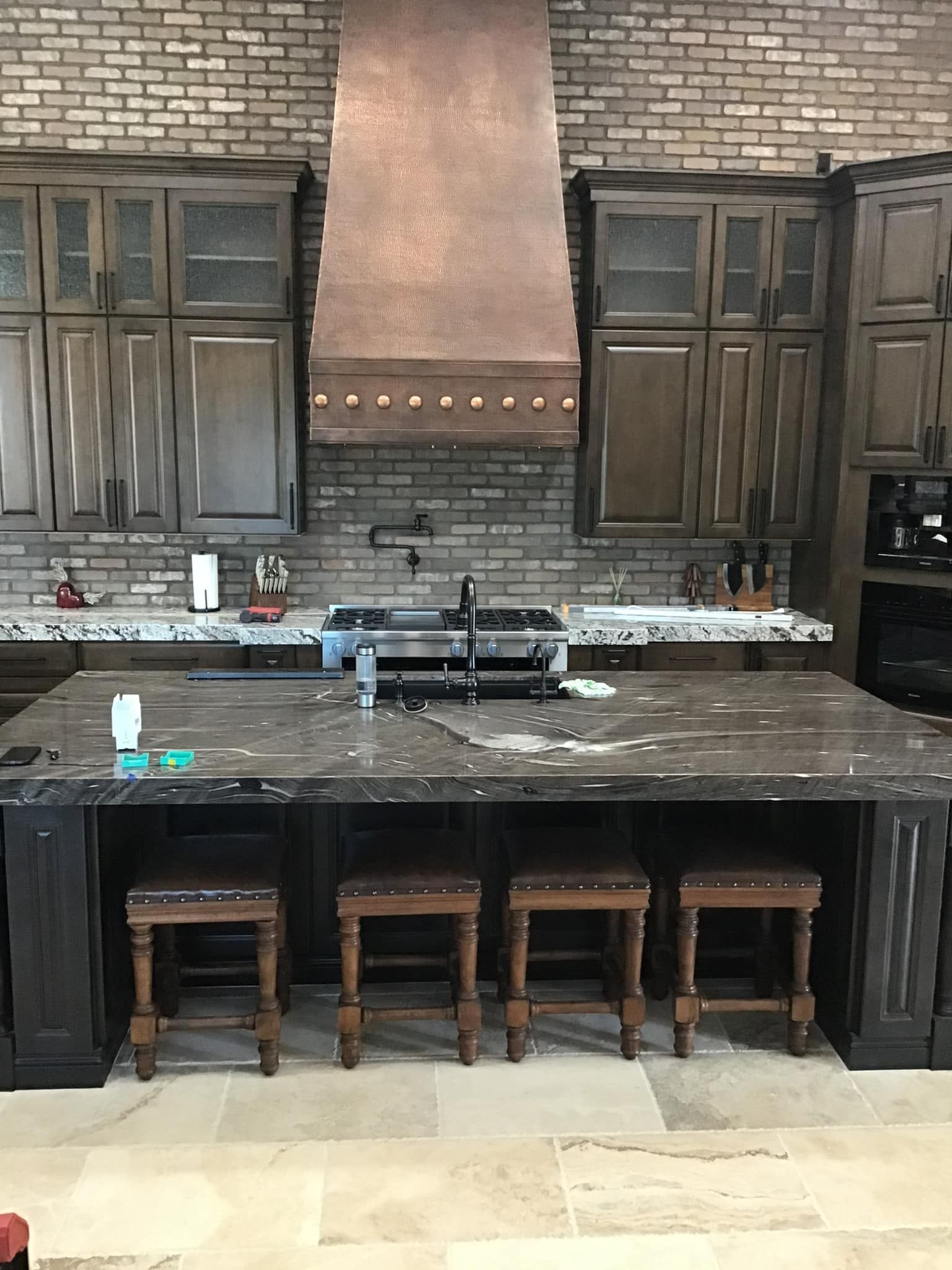A kitchen with a large island and stools.