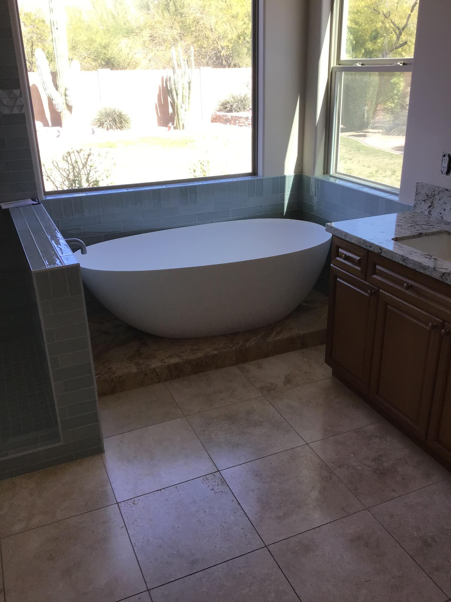 A bathtub in a bathroom next to a window.