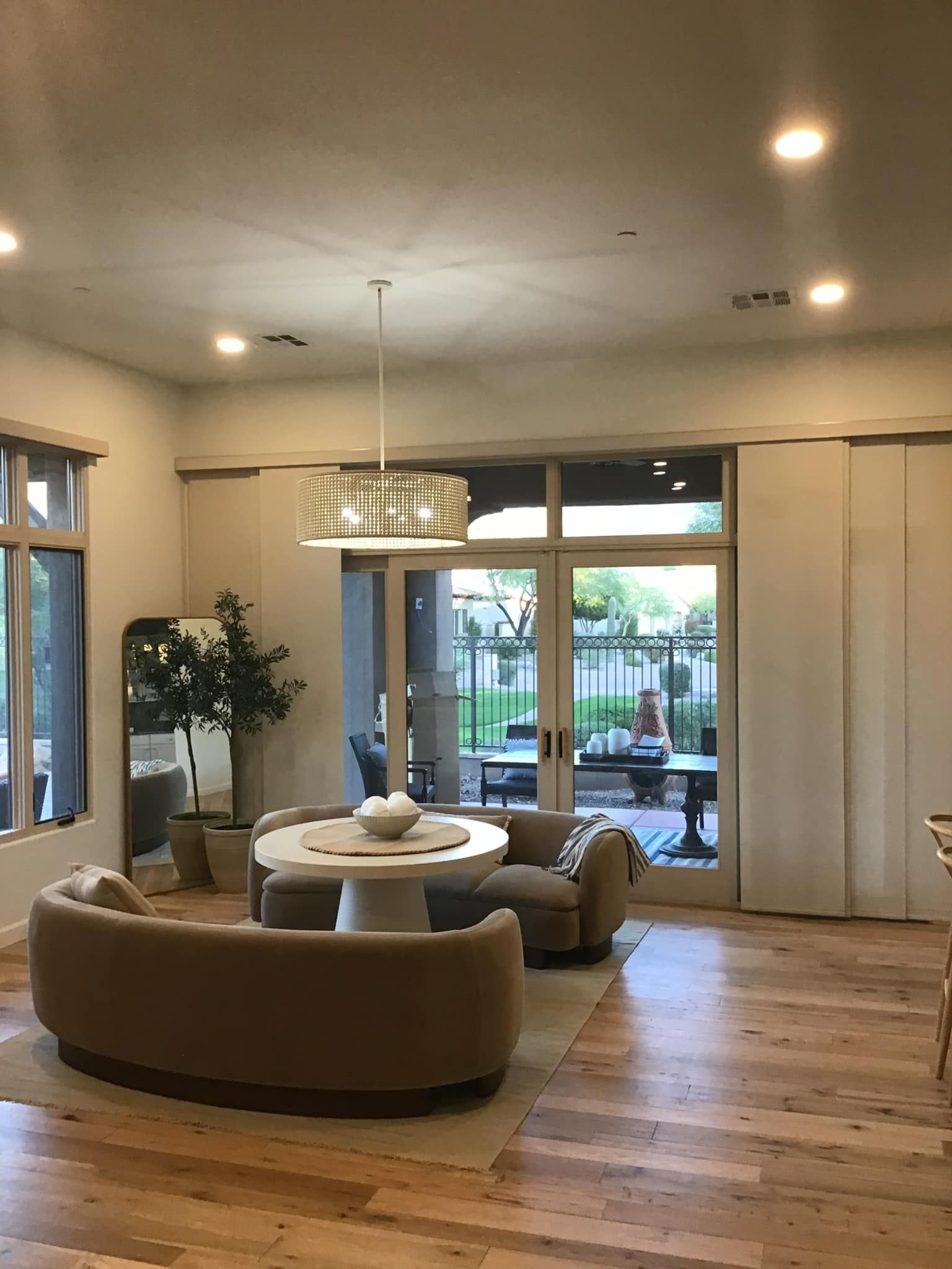 A living room with a couch , chair , table and sliding glass doors.