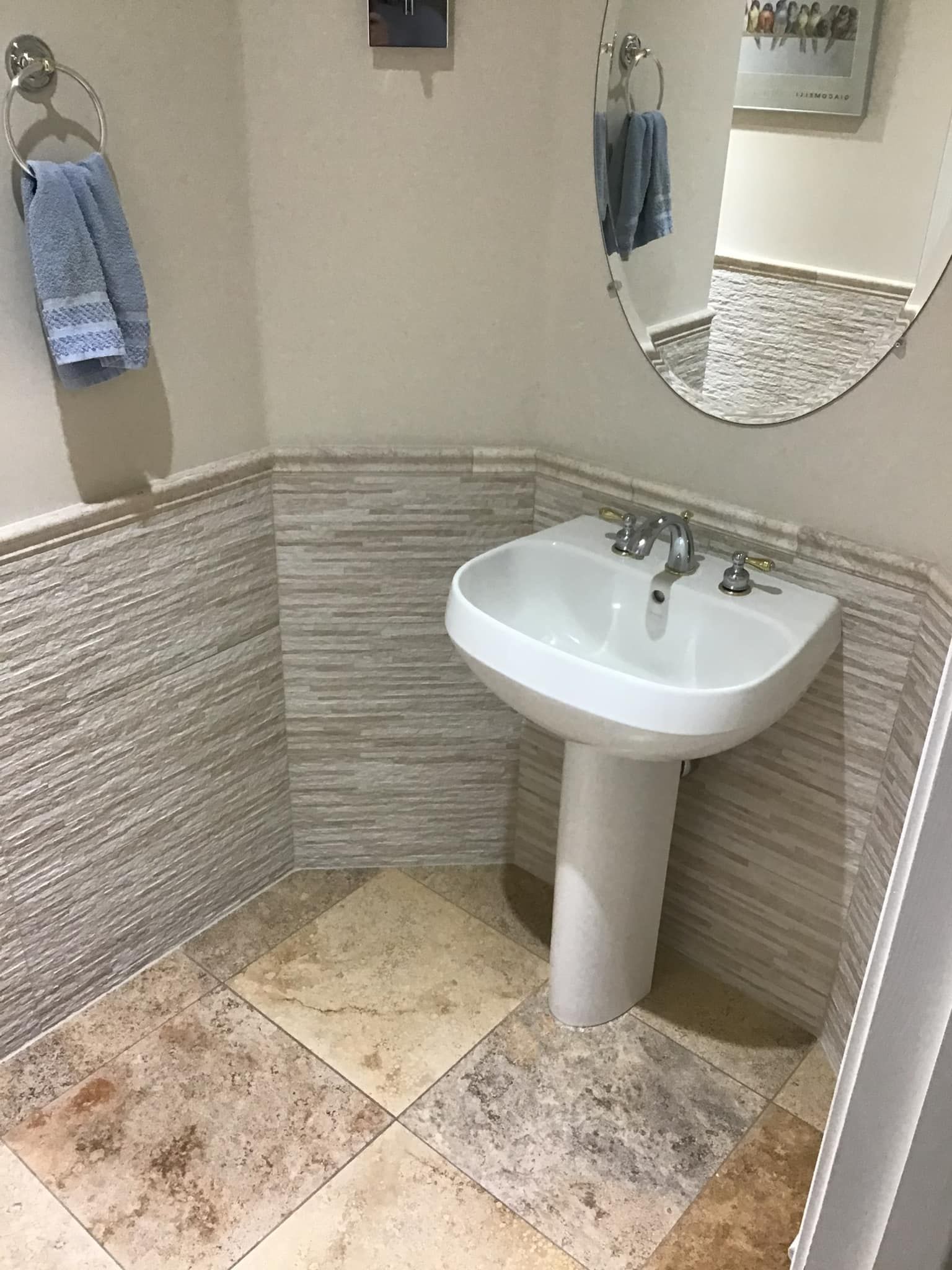 A bathroom with a pedestal sink and a mirror.