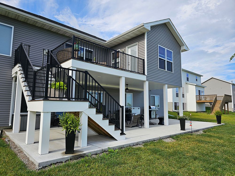 The back of a house with a large deck and stairs.