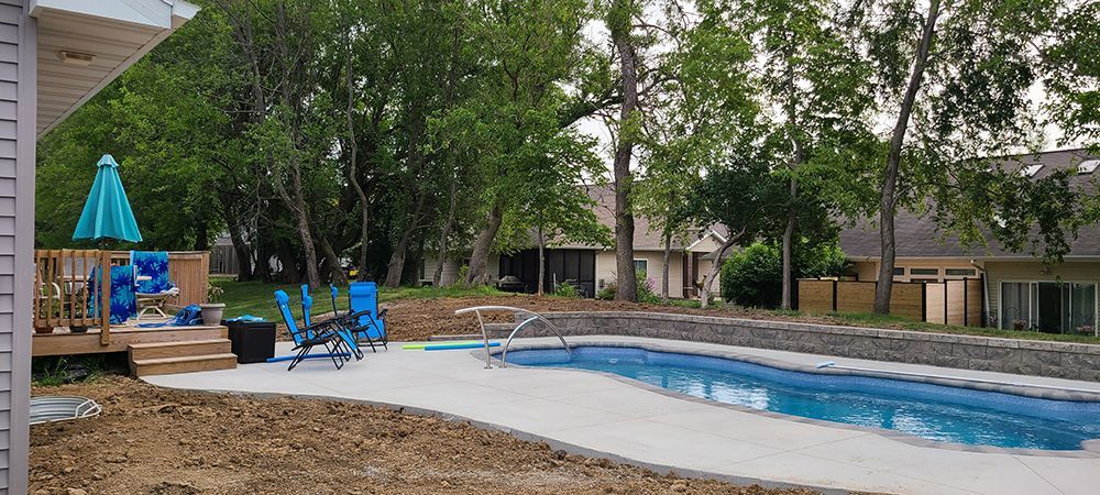 There is a large swimming pool in the backyard of a house.