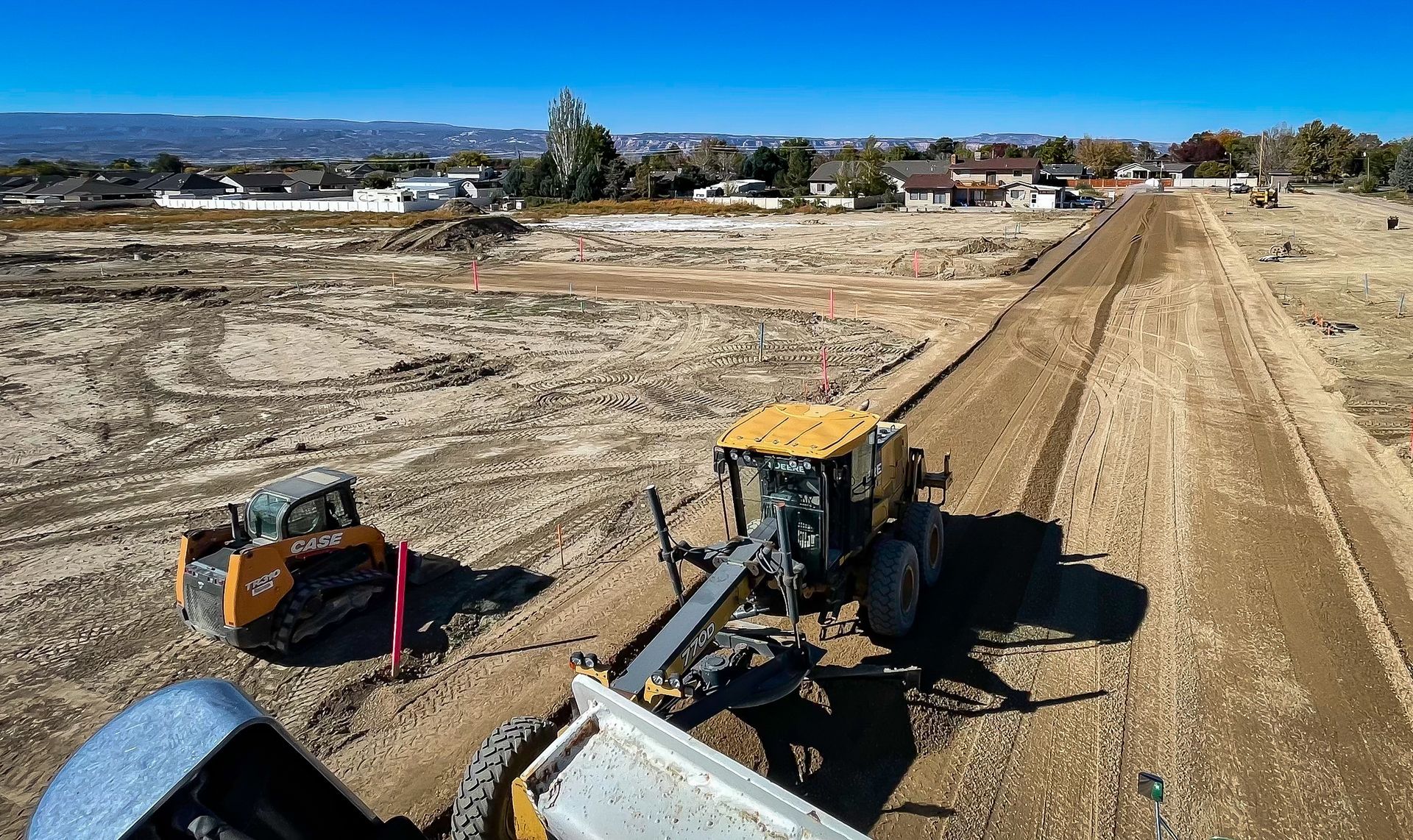 A bulldozer is moving dirt on a dirt road.