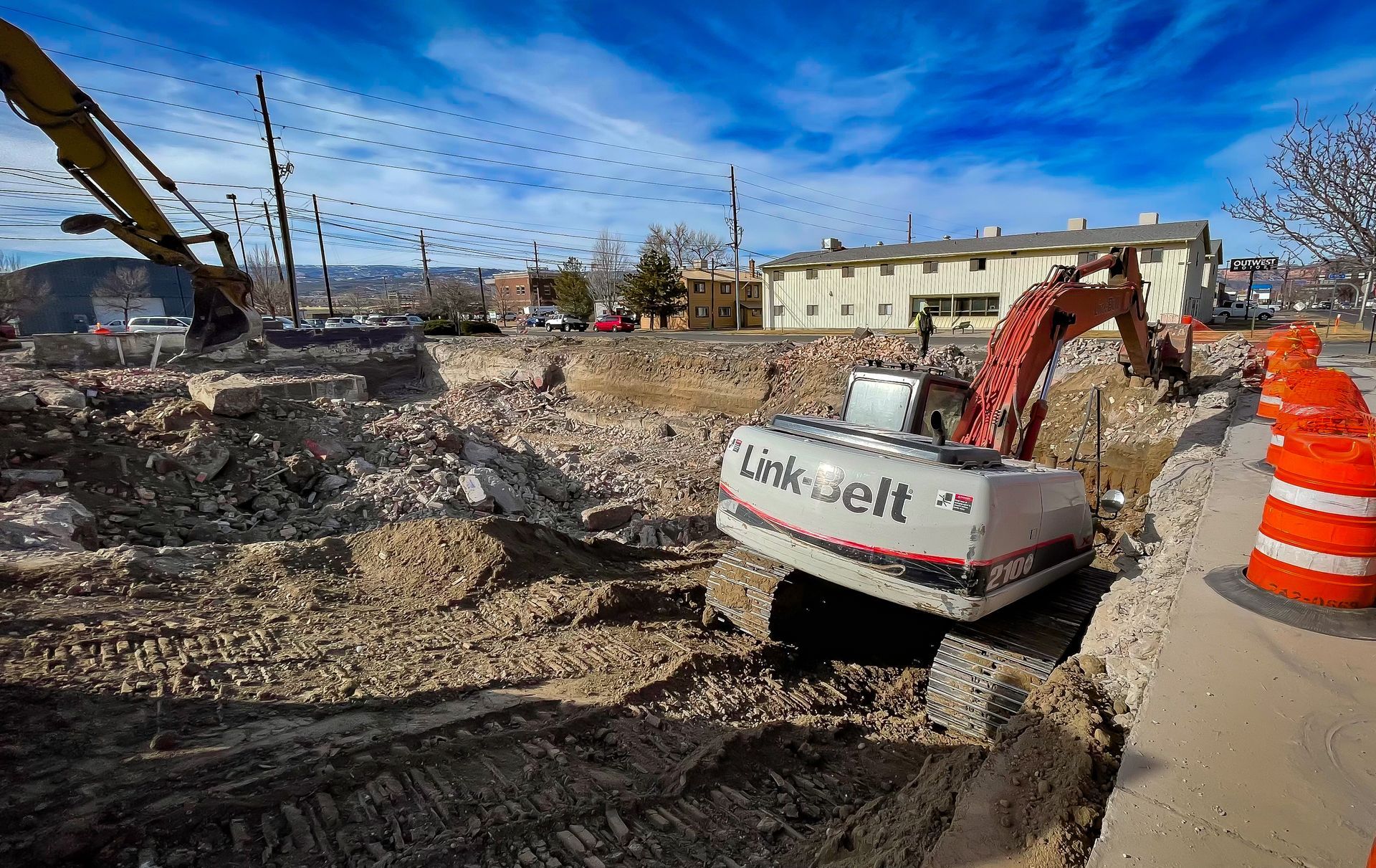 A construction site with a link belt excavator in the foreground