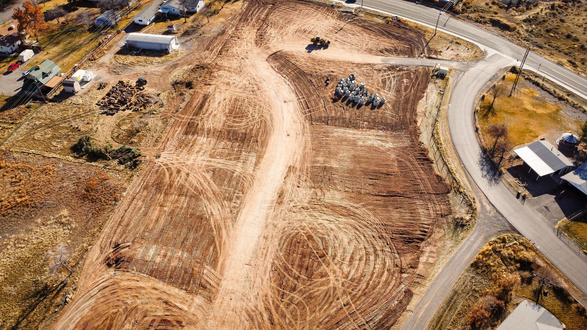 An aerial view of a construction site with a lot of dirt and a road.