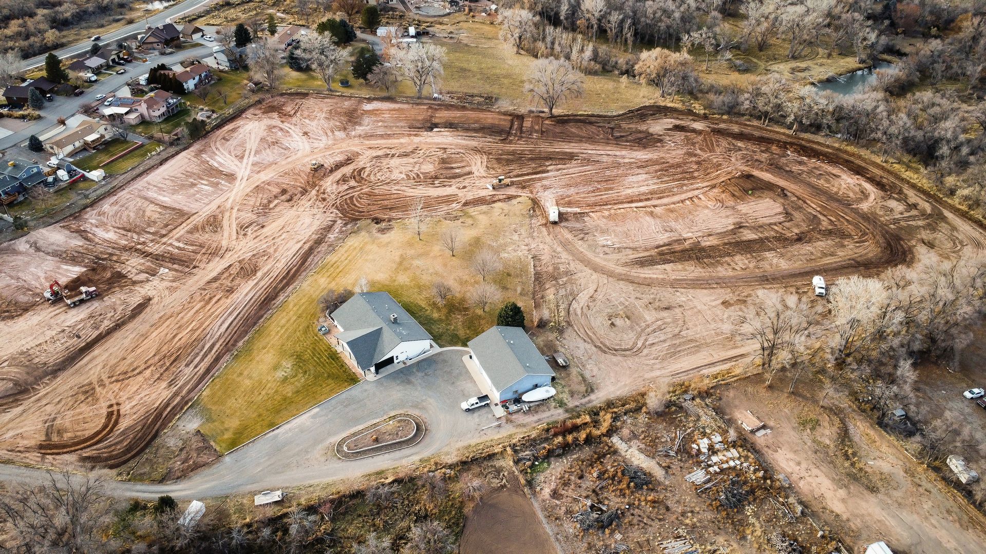 An aerial view of a large dirt field with houses in the middle of it.