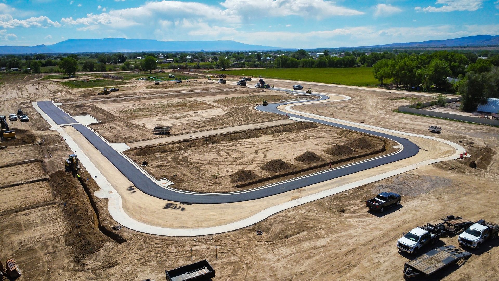 An aerial view of a construction site with trucks parked on the side of the road.