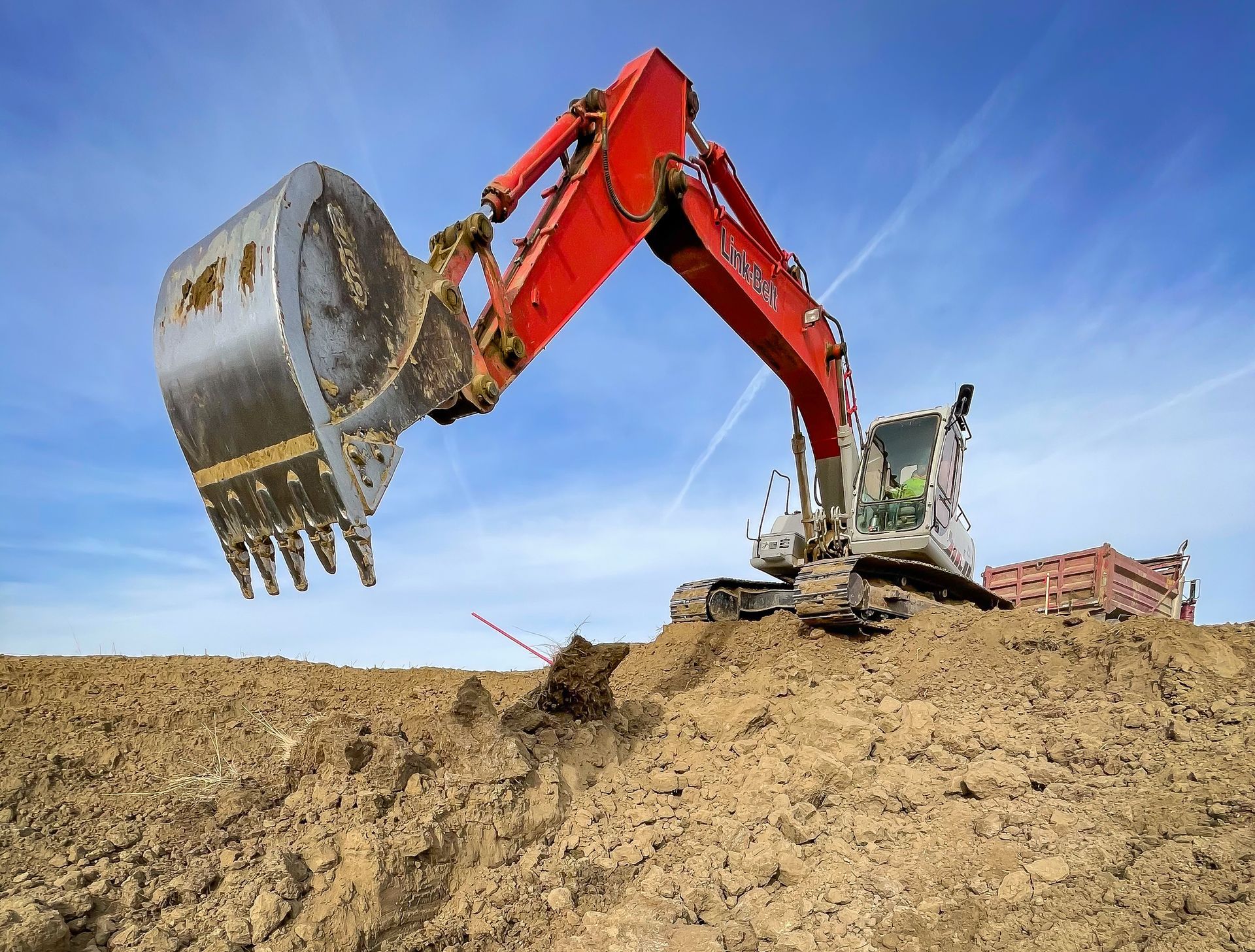 A large excavator is digging a hole in a dirt field.