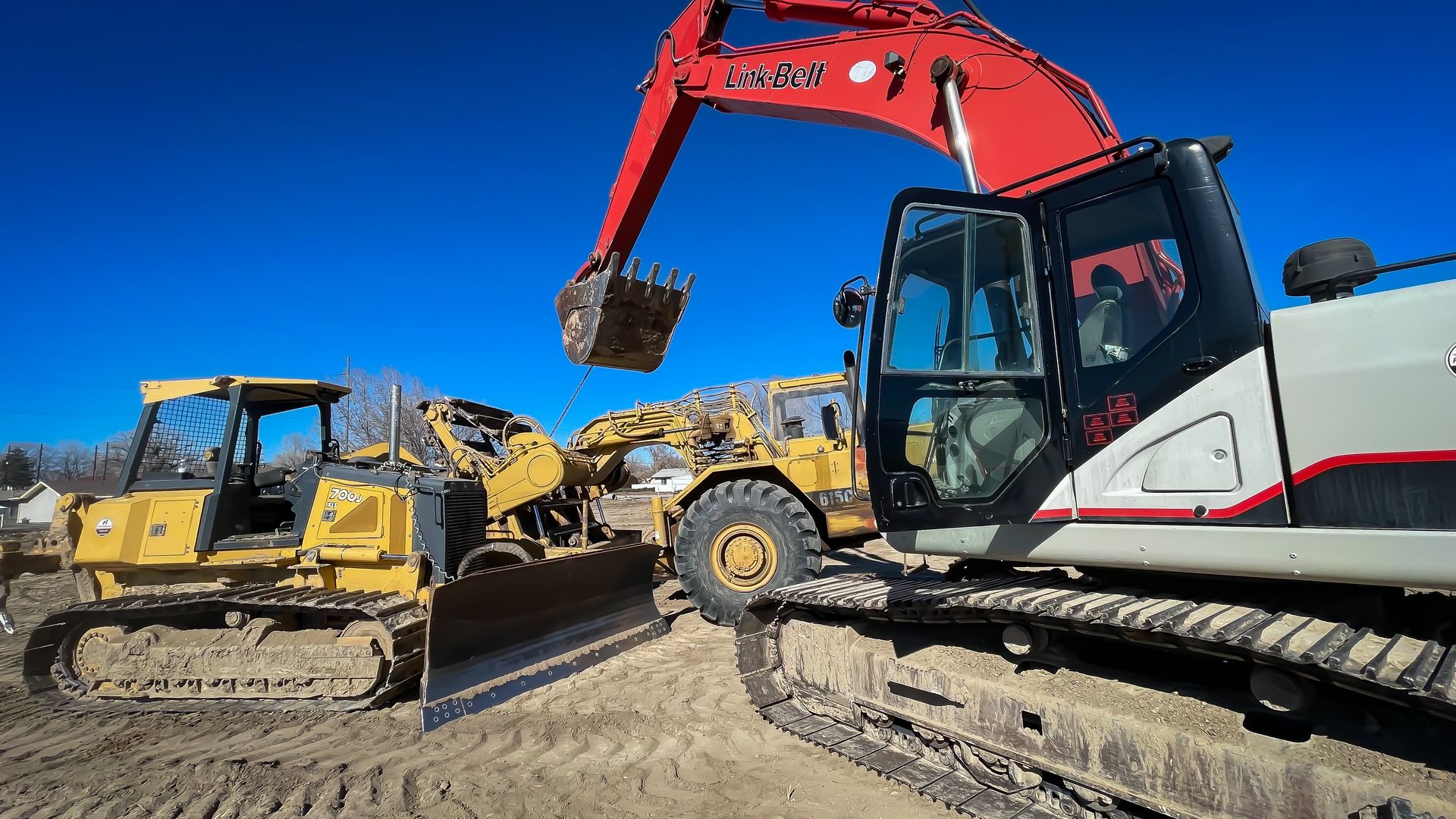 A bulldozer and an excavator are working on a construction site.