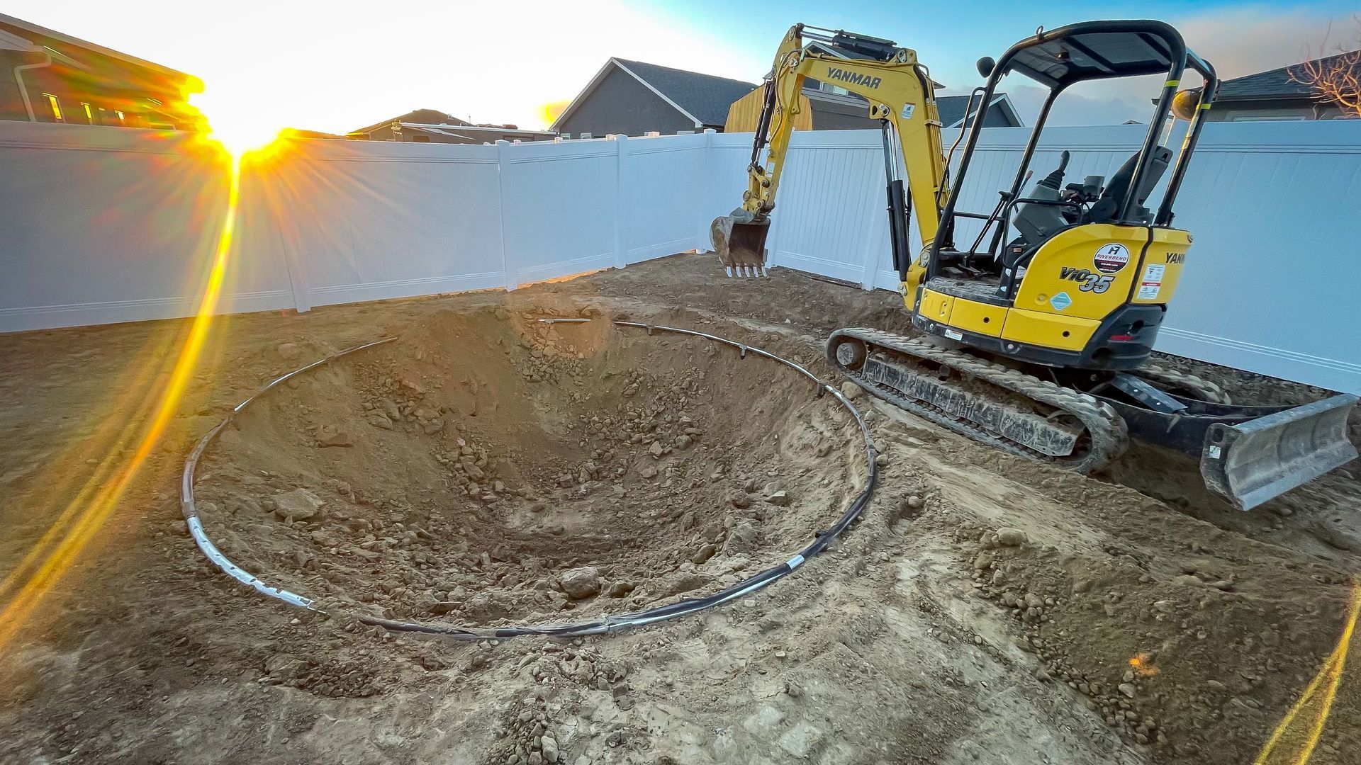 A yellow excavator is digging a hole in the dirt.