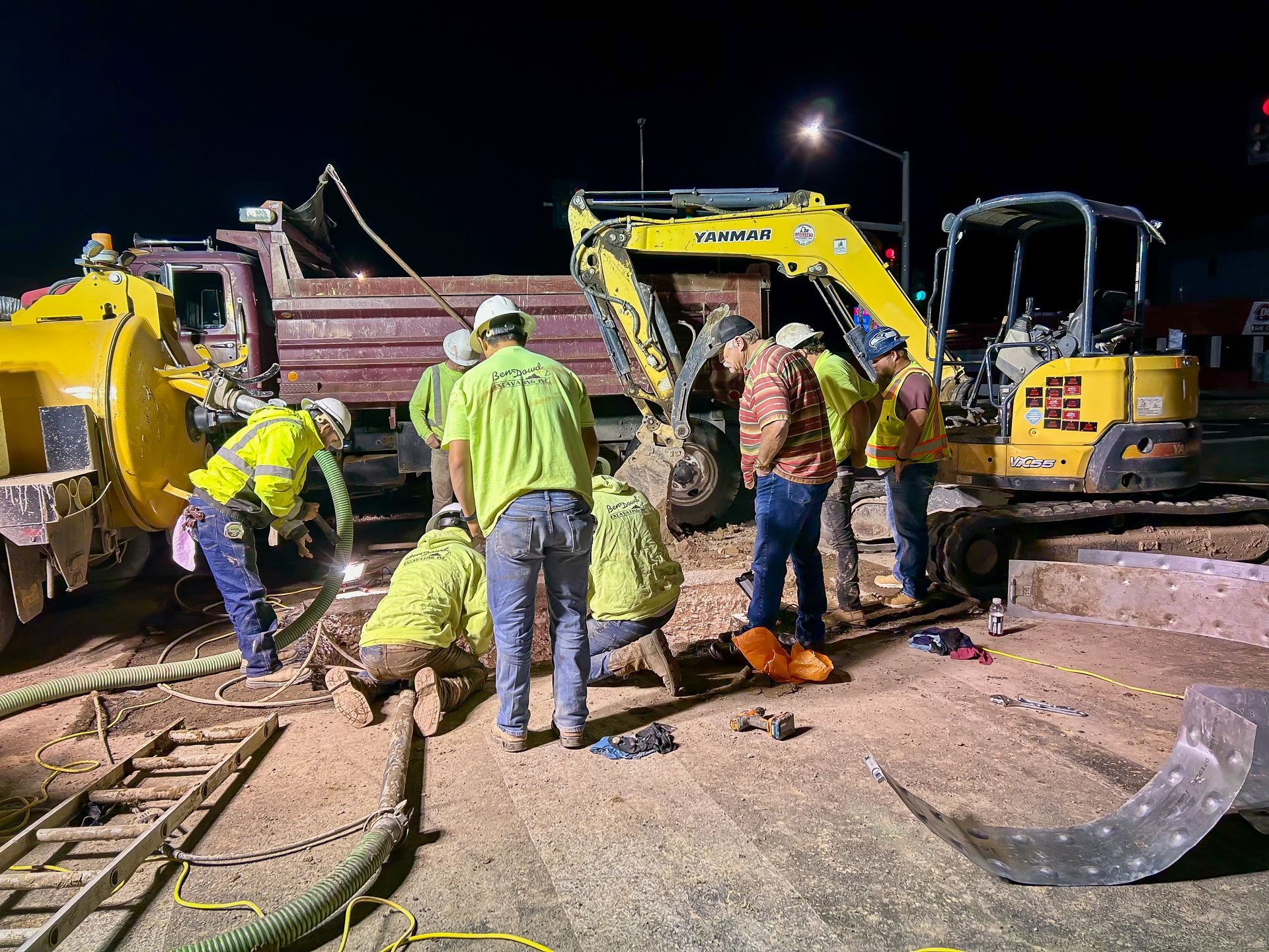 A group of construction workers are working on a construction site at night.