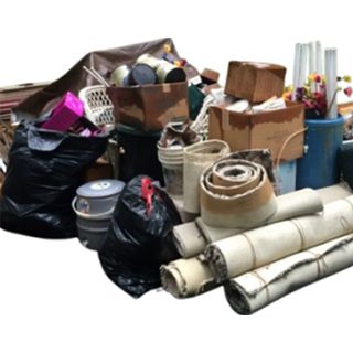 Pile of junk, including black trash bags, cardboard boxes, buckets, and rolled-up rugs.