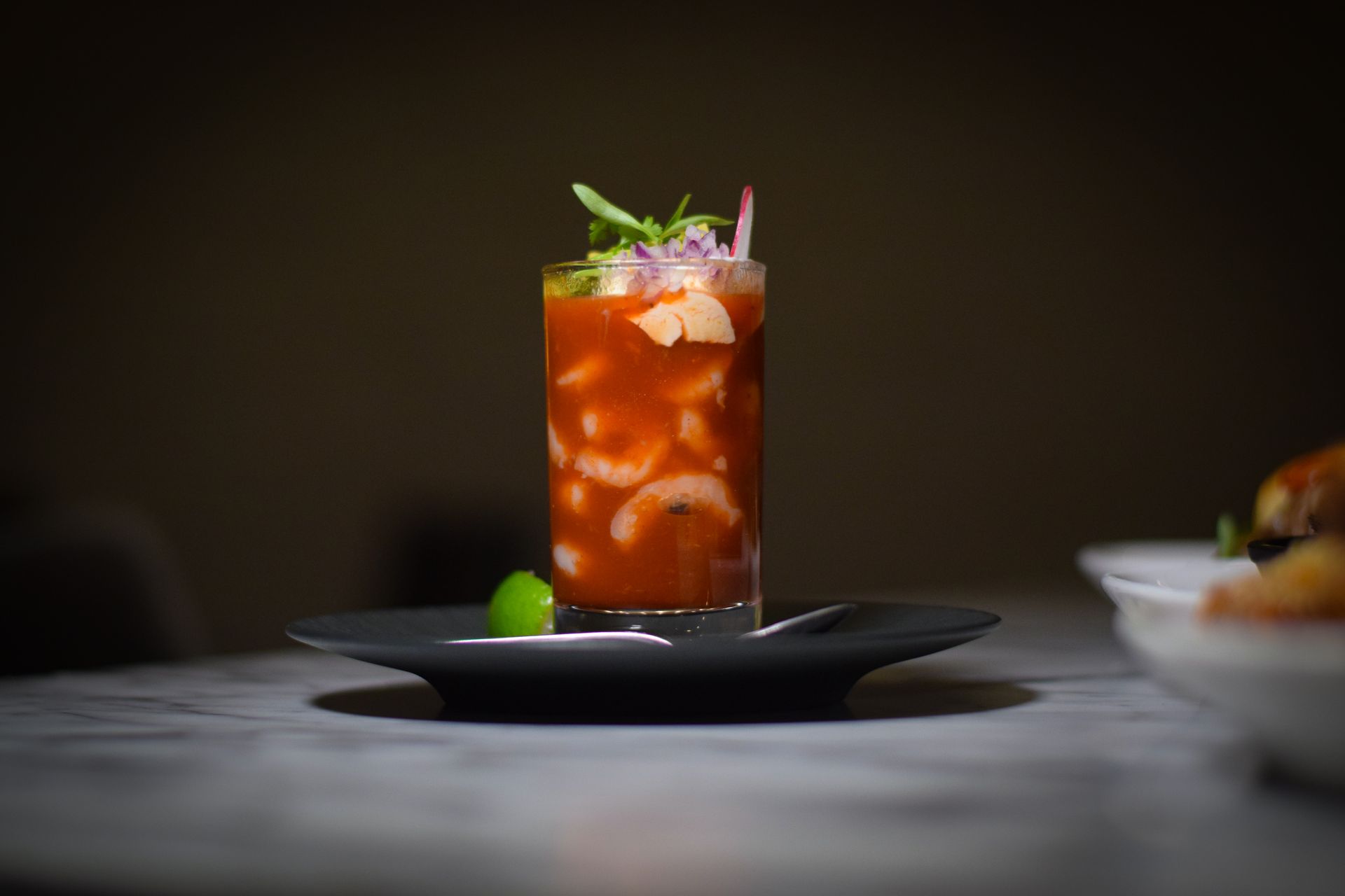 A close up of a drink on a plate on a table.