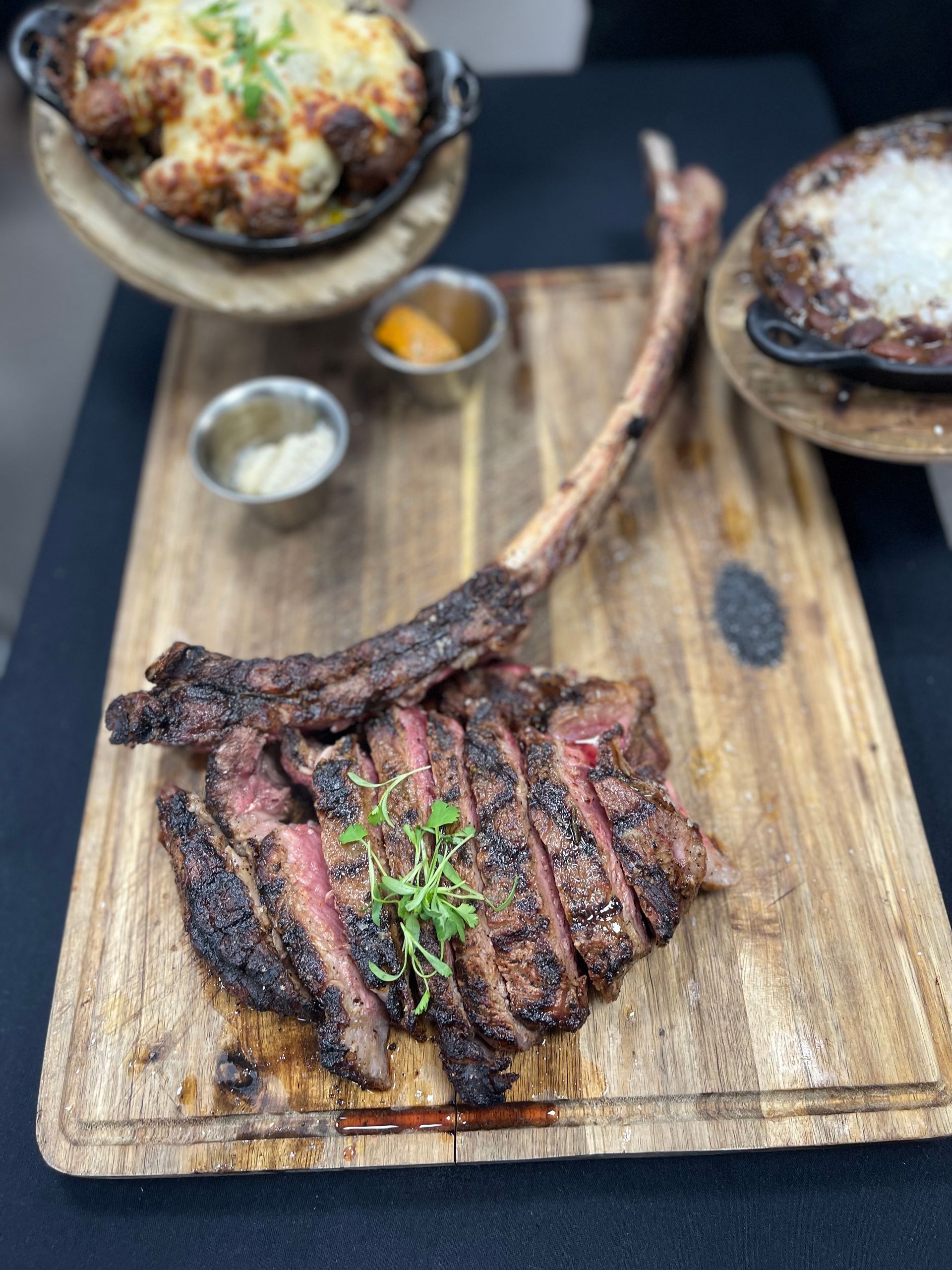 A large steak is sitting on a wooden cutting board.