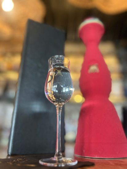 A wine glass sitting on a table next to a menu