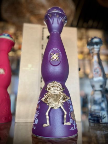 A purple bottle with a skeleton on it