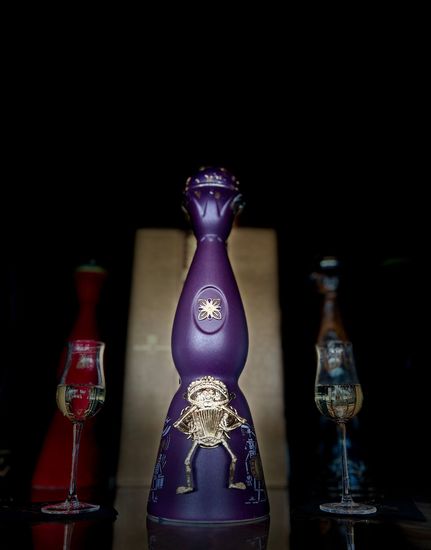A purple bottle with a skeleton on it