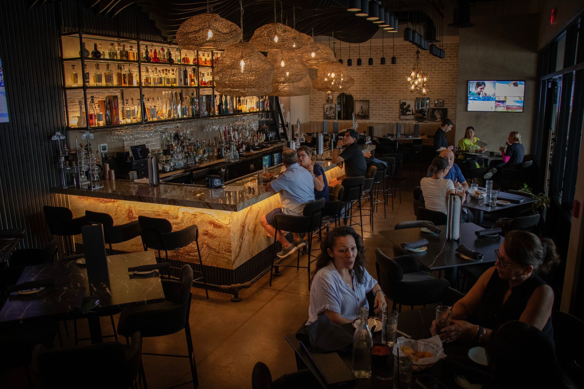A group of people are sitting at tables in a restaurant.