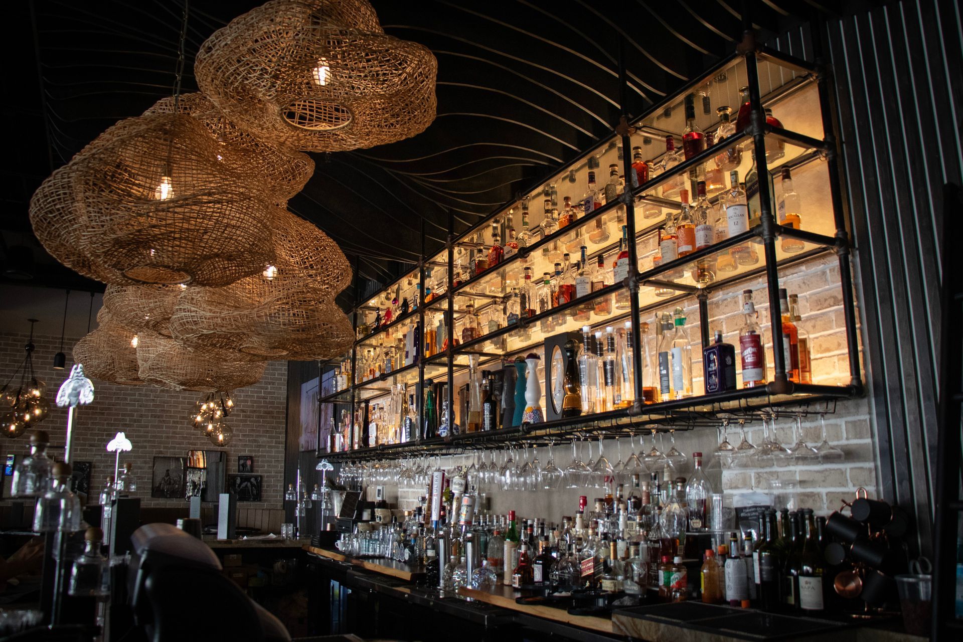 A bar filled with lots of bottles of liquor and glasses.