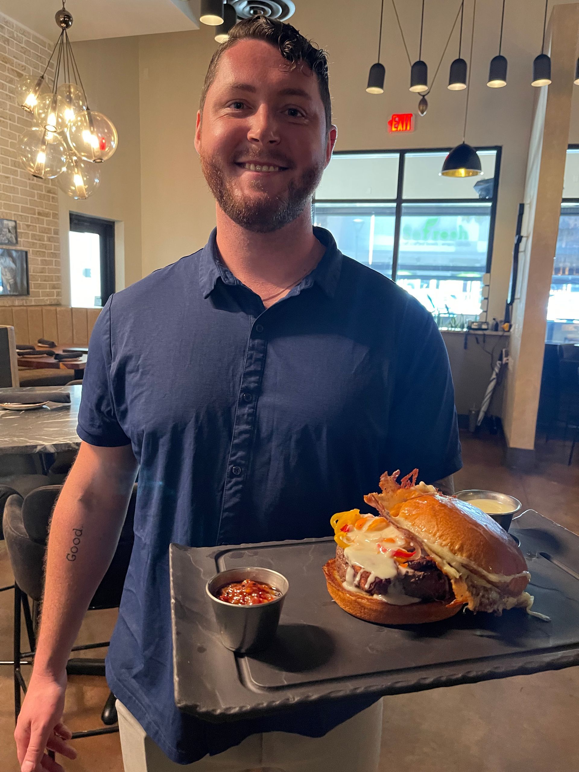 A man is holding a tray of food in a restaurant.