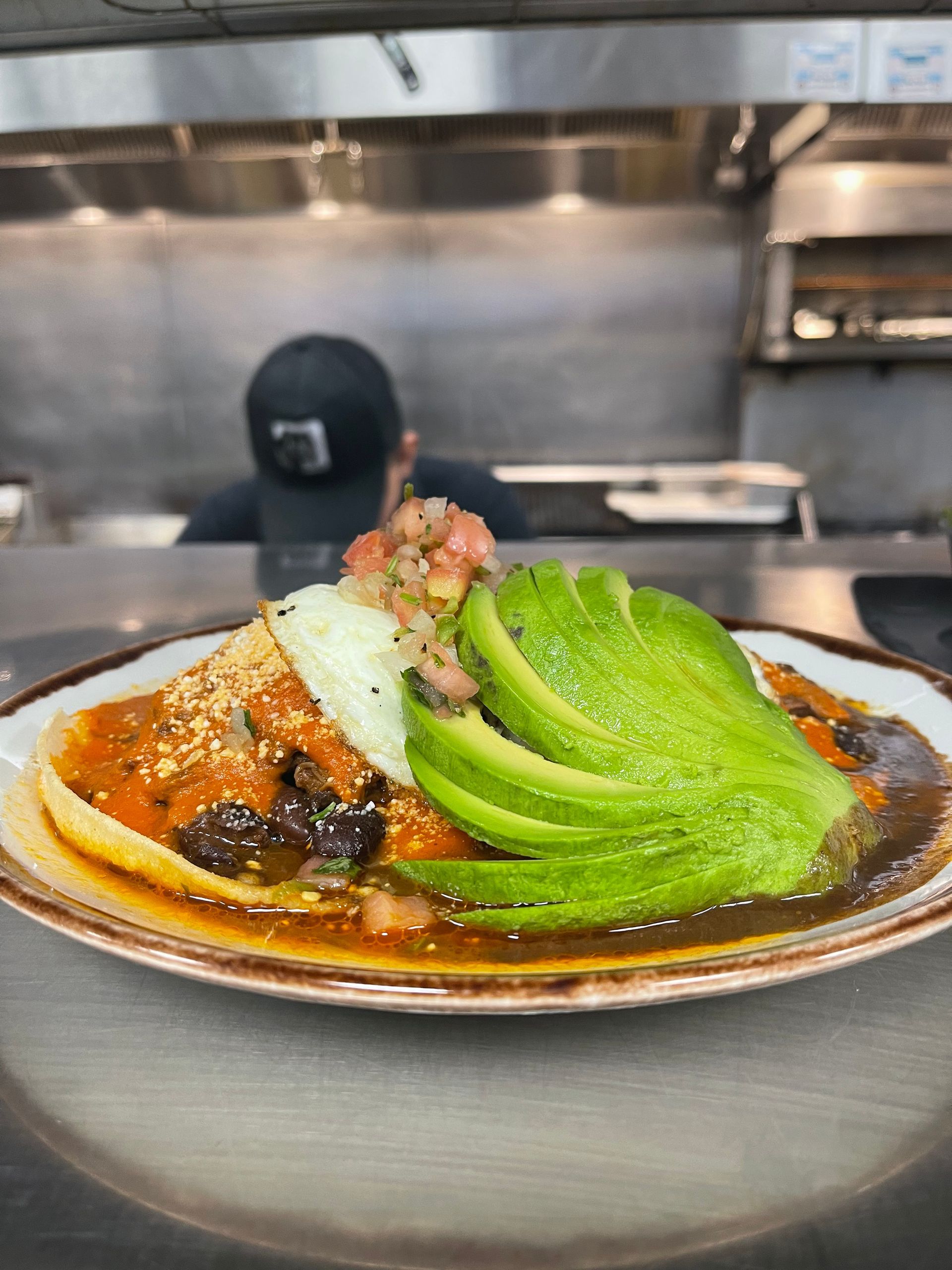 A close up of a plate of food with avocado on top.