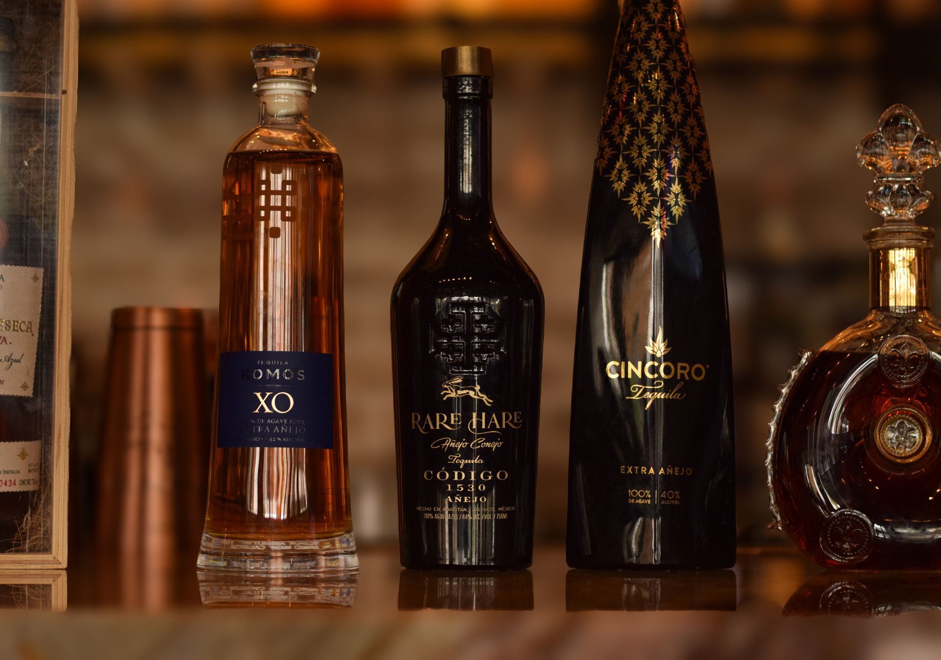 Three bottles of alcohol are sitting on a table.