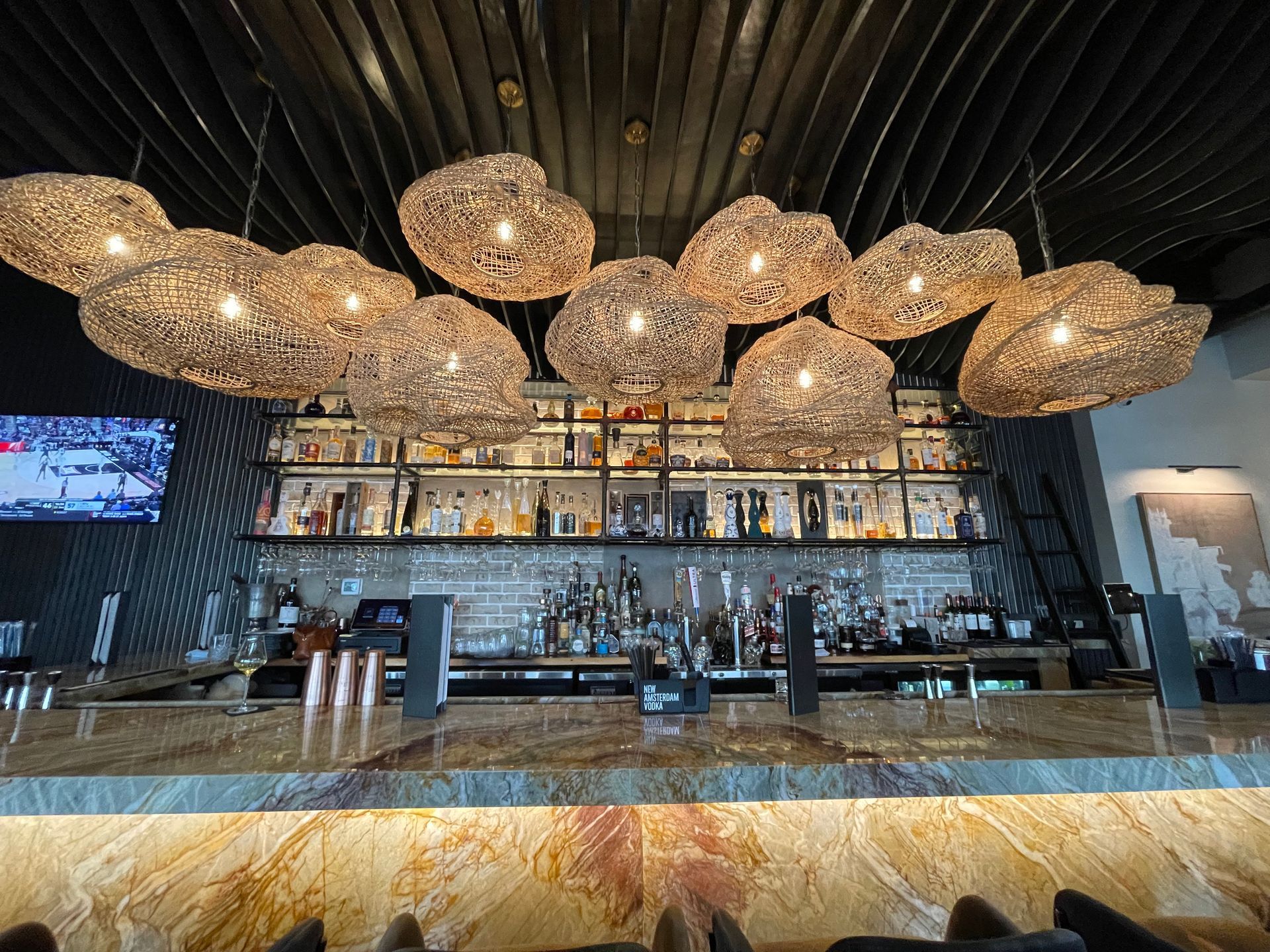 A bar in a restaurant with a lot of lights hanging from the ceiling.