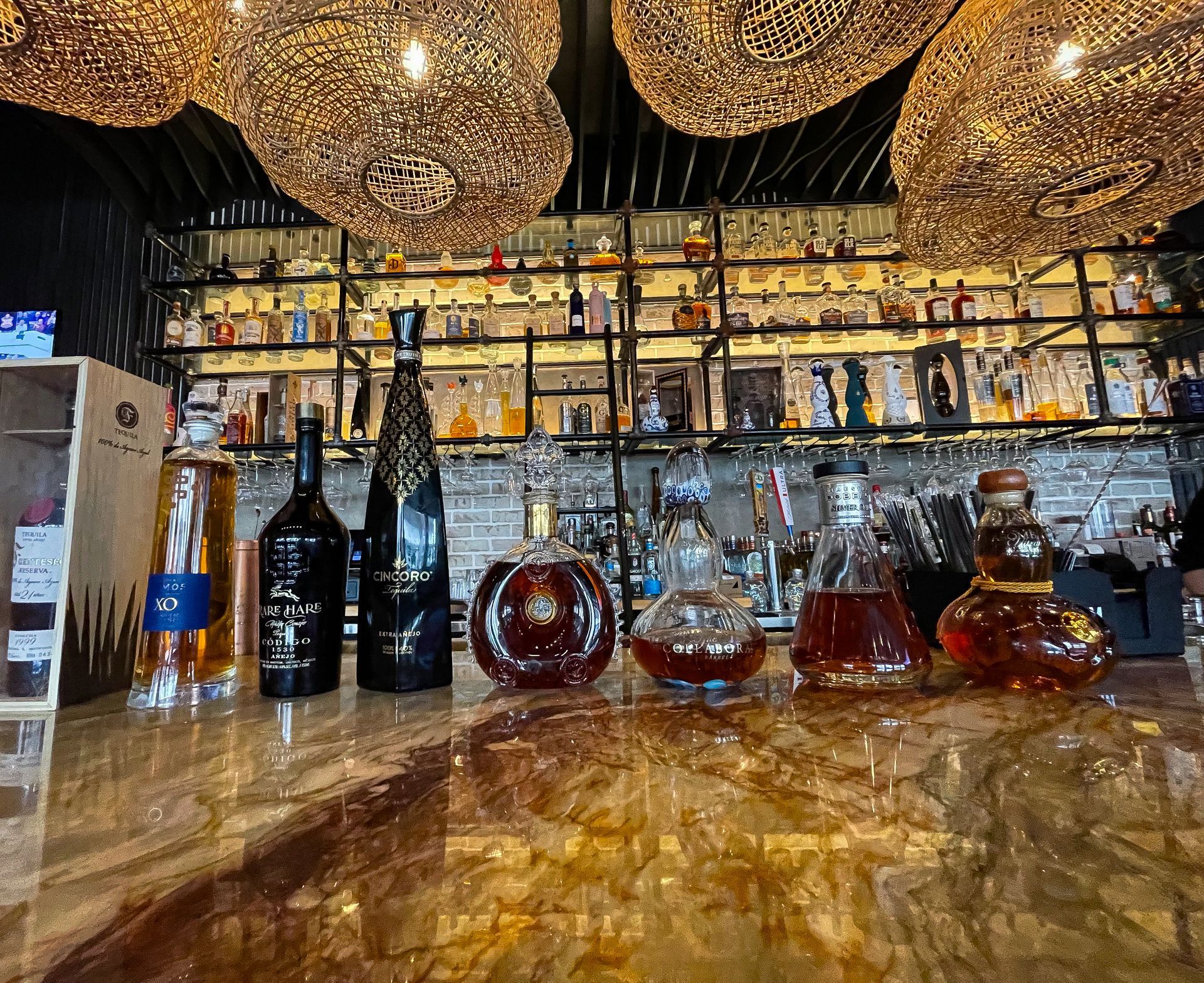 A bar with a lot of bottles of alcohol on it.