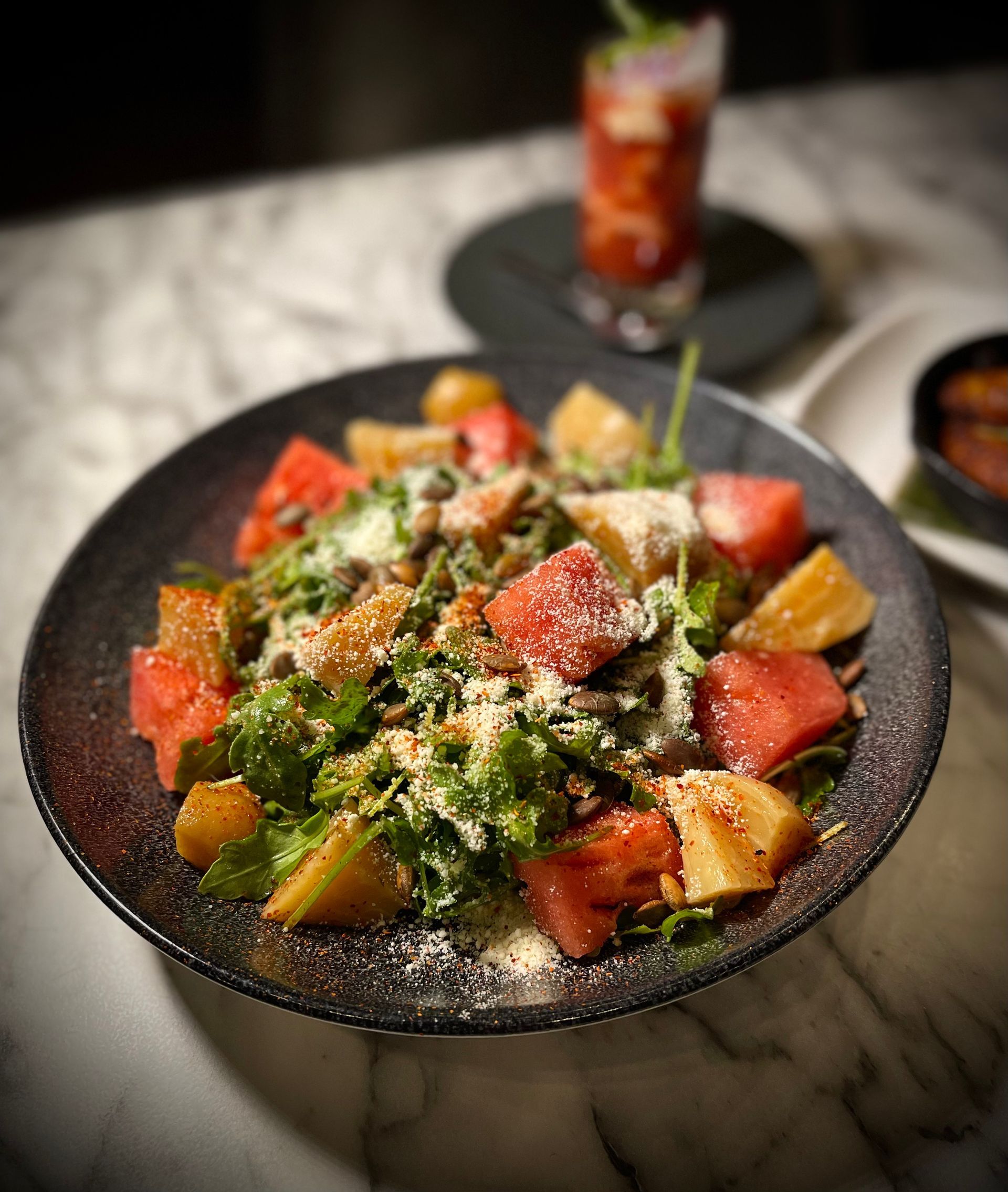 A close up of a salad on a plate on a table.