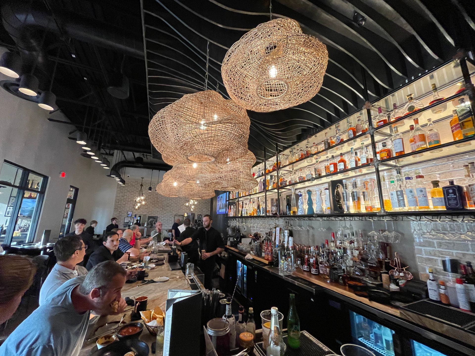 A group of people are sitting at a bar in a restaurant.