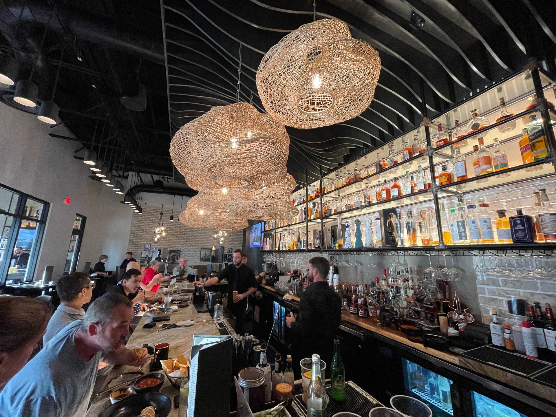 A group of people are sitting at a bar in a restaurant.