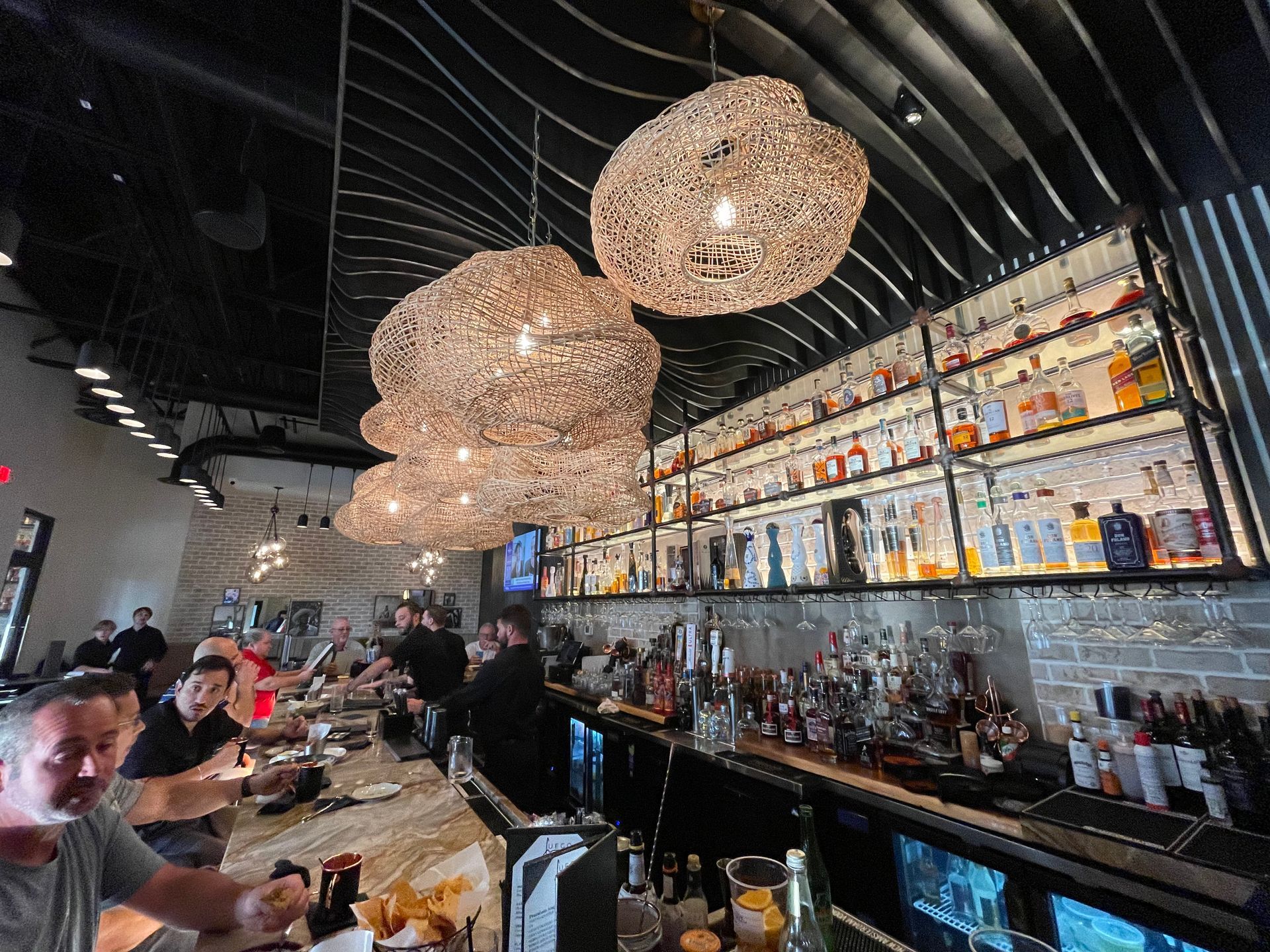 A group of people are sitting at a bar in a restaurant.