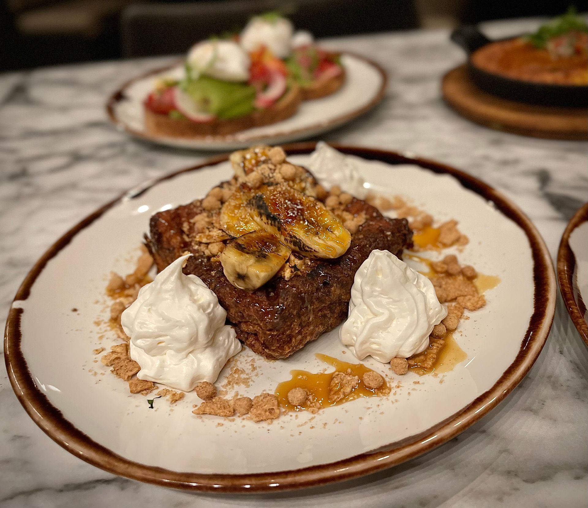 A plate of food with bananas and whipped cream on it