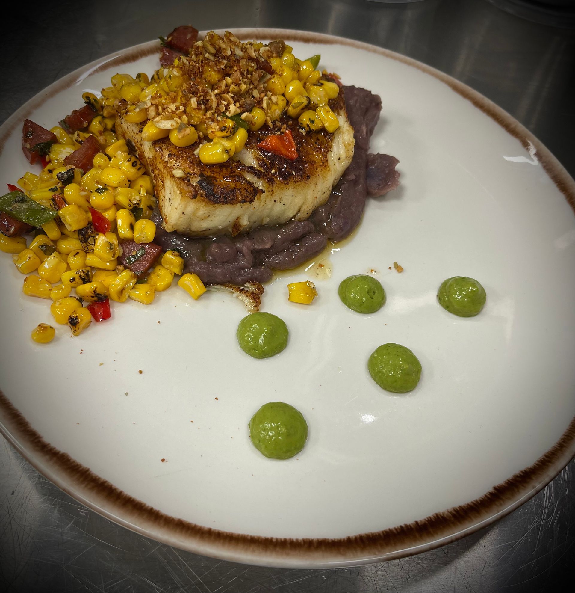 A plate of food with corn and beans on it