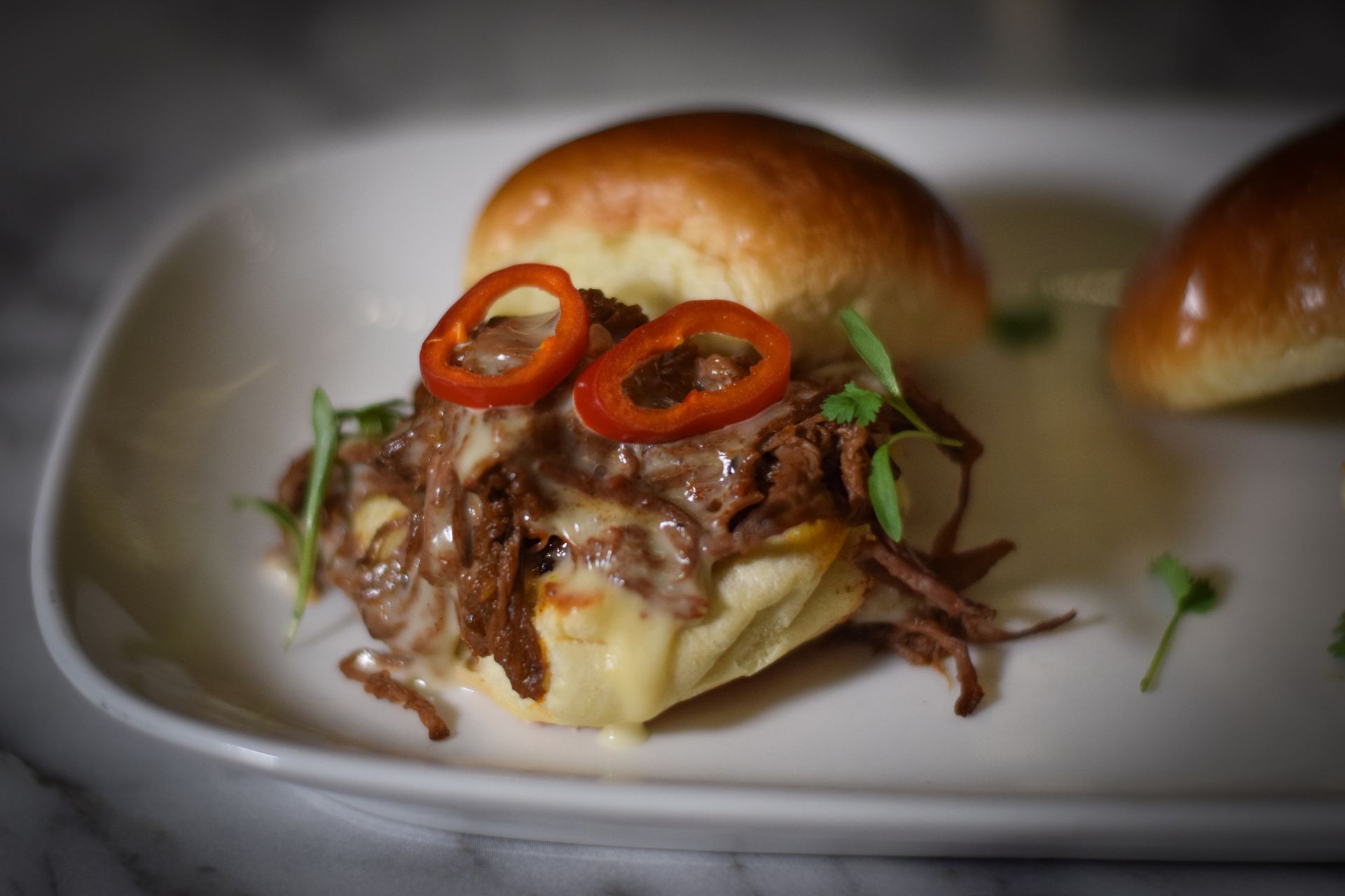 A close up of a sandwich on a white plate on a table.