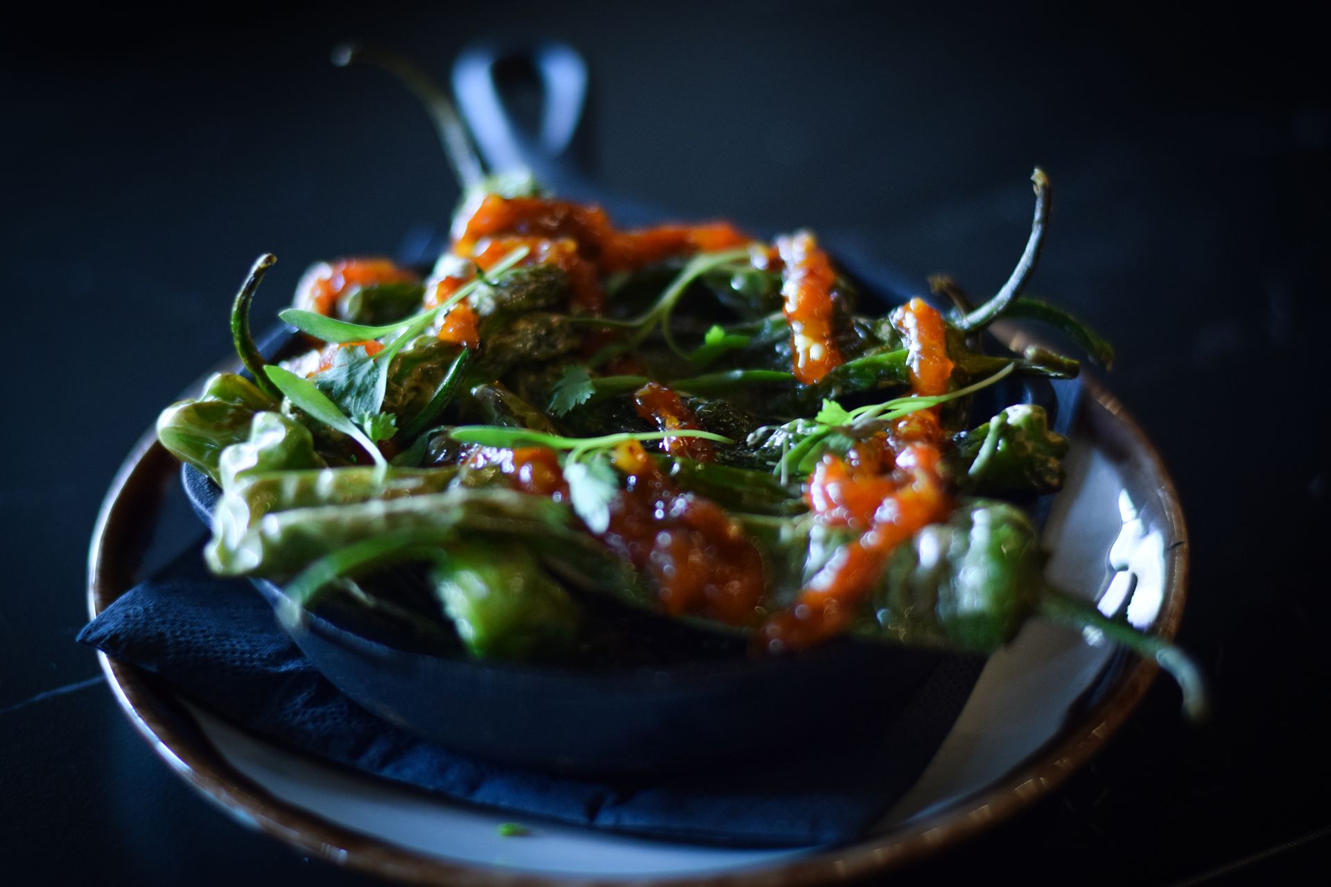 A close up of a plate of food with peppers and sauce