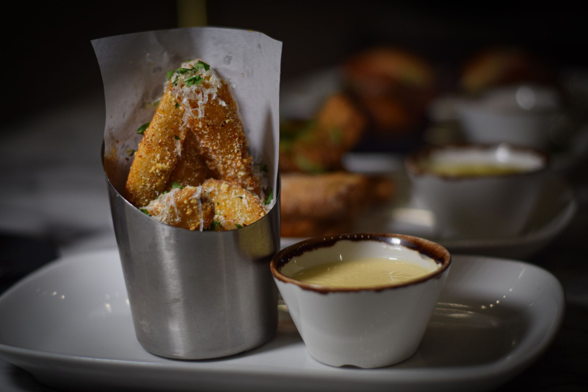 A close up of a plate of food with a bowl of sauce.