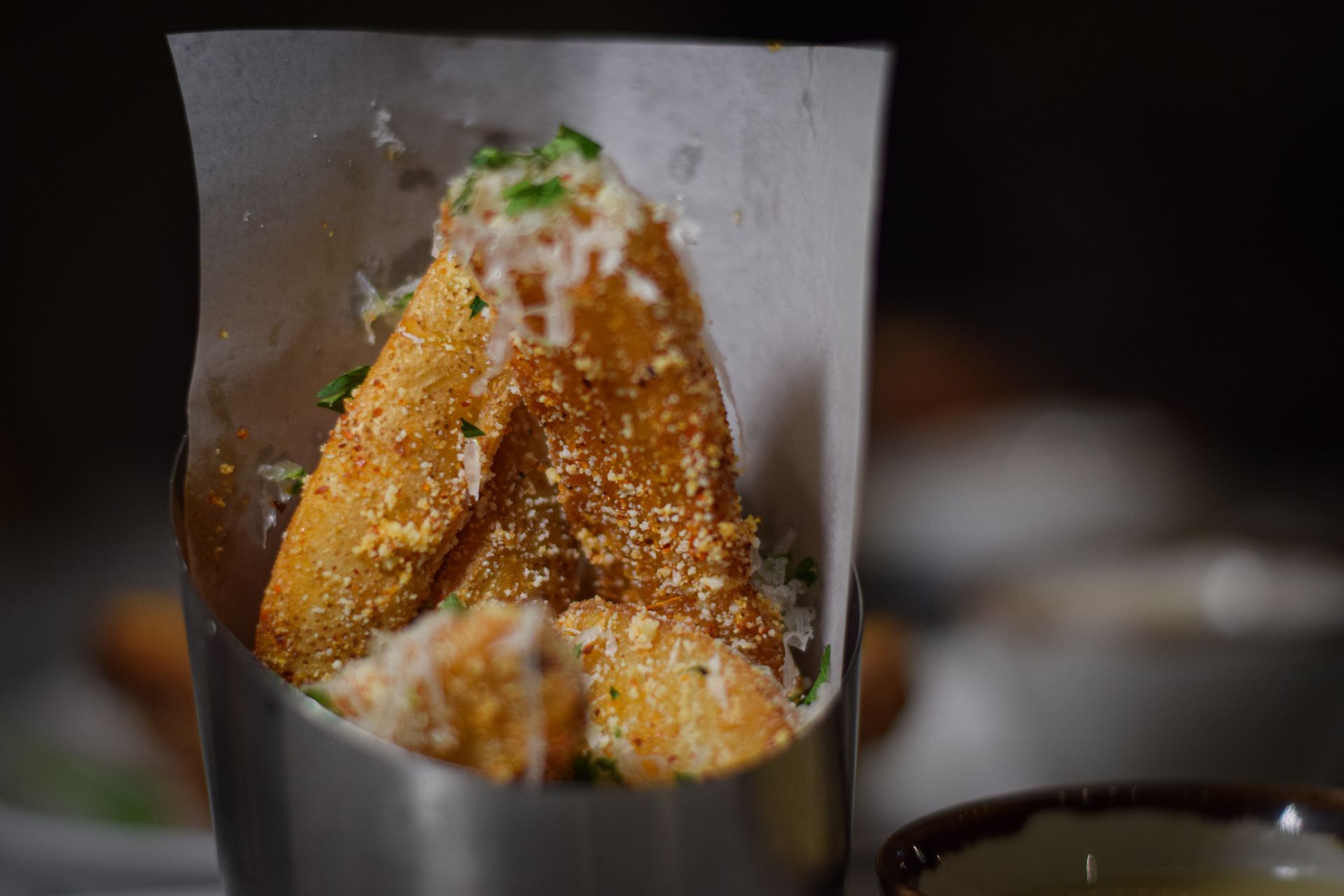 A close up of a fried food item in a metal container on a table.