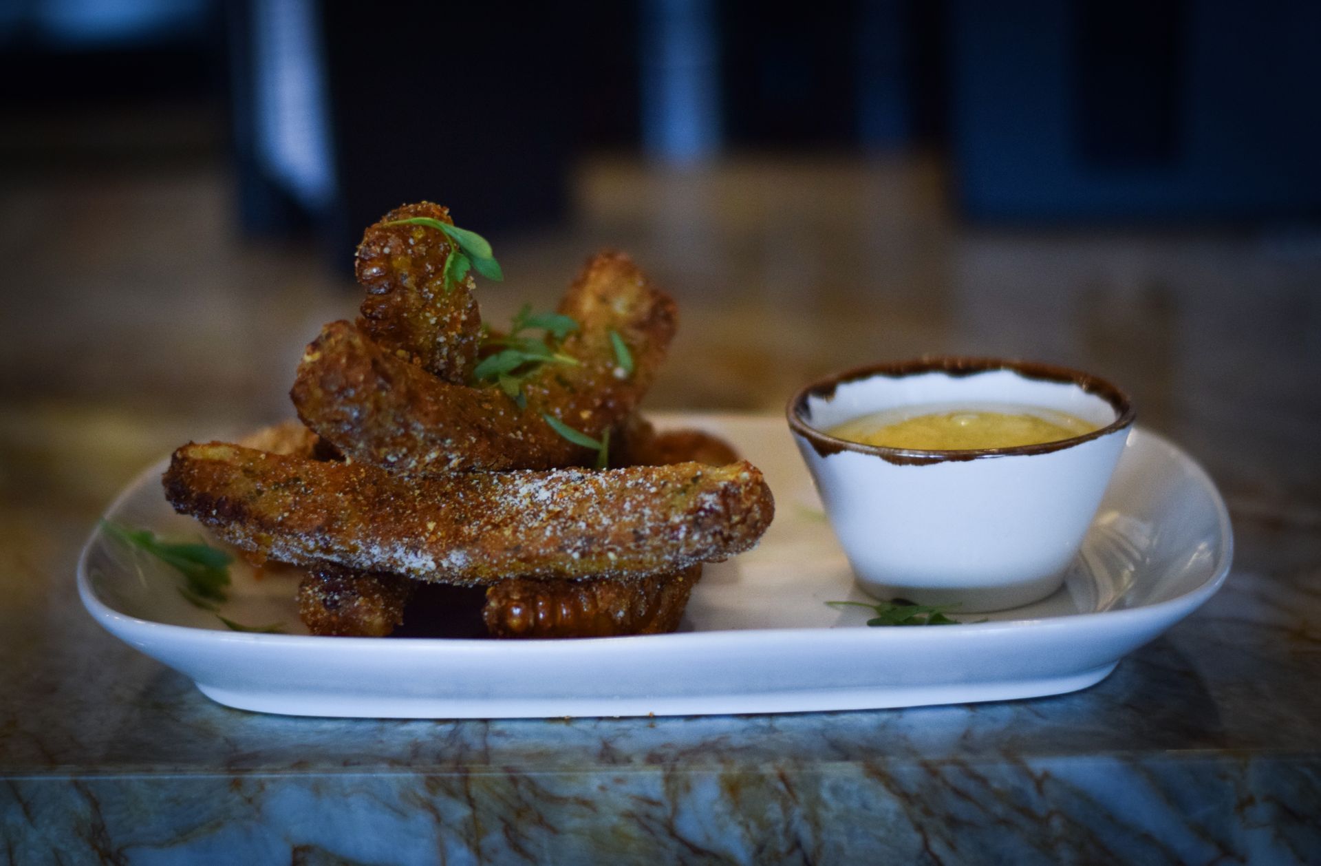 A plate of food with a bowl of dipping sauce on a table.