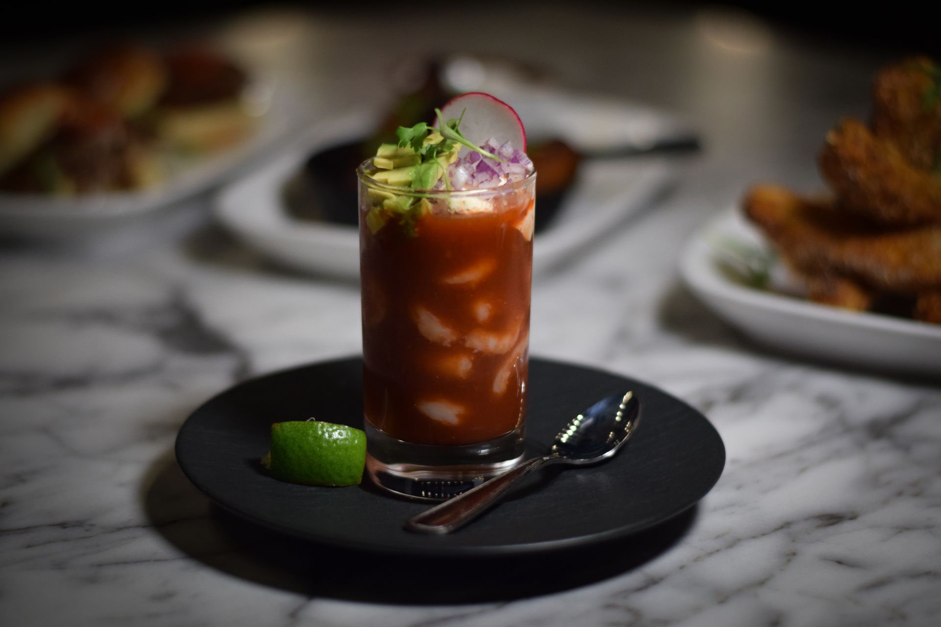 A close up of a drink on a plate with a spoon