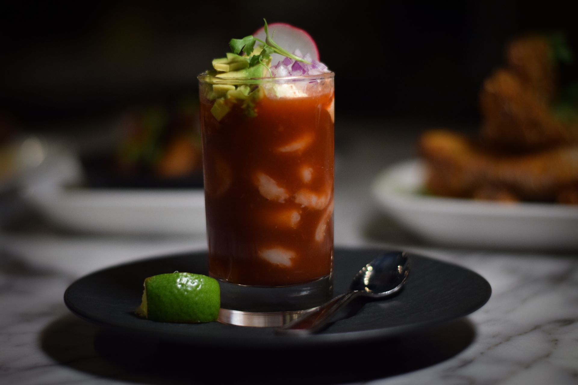 A close up of a drink on a plate with a spoon.