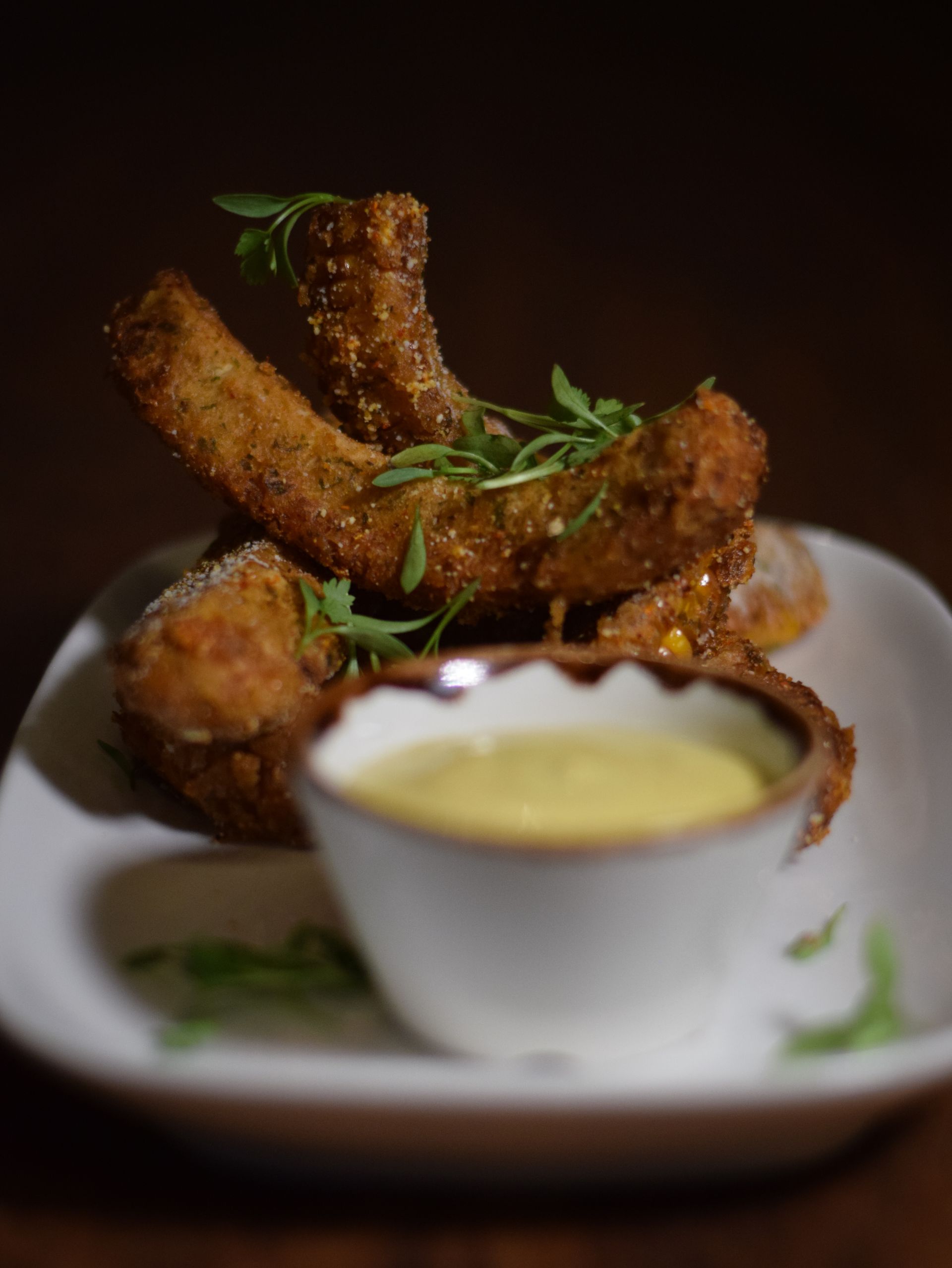 A close up of a plate of food with a bowl of dipping sauce.